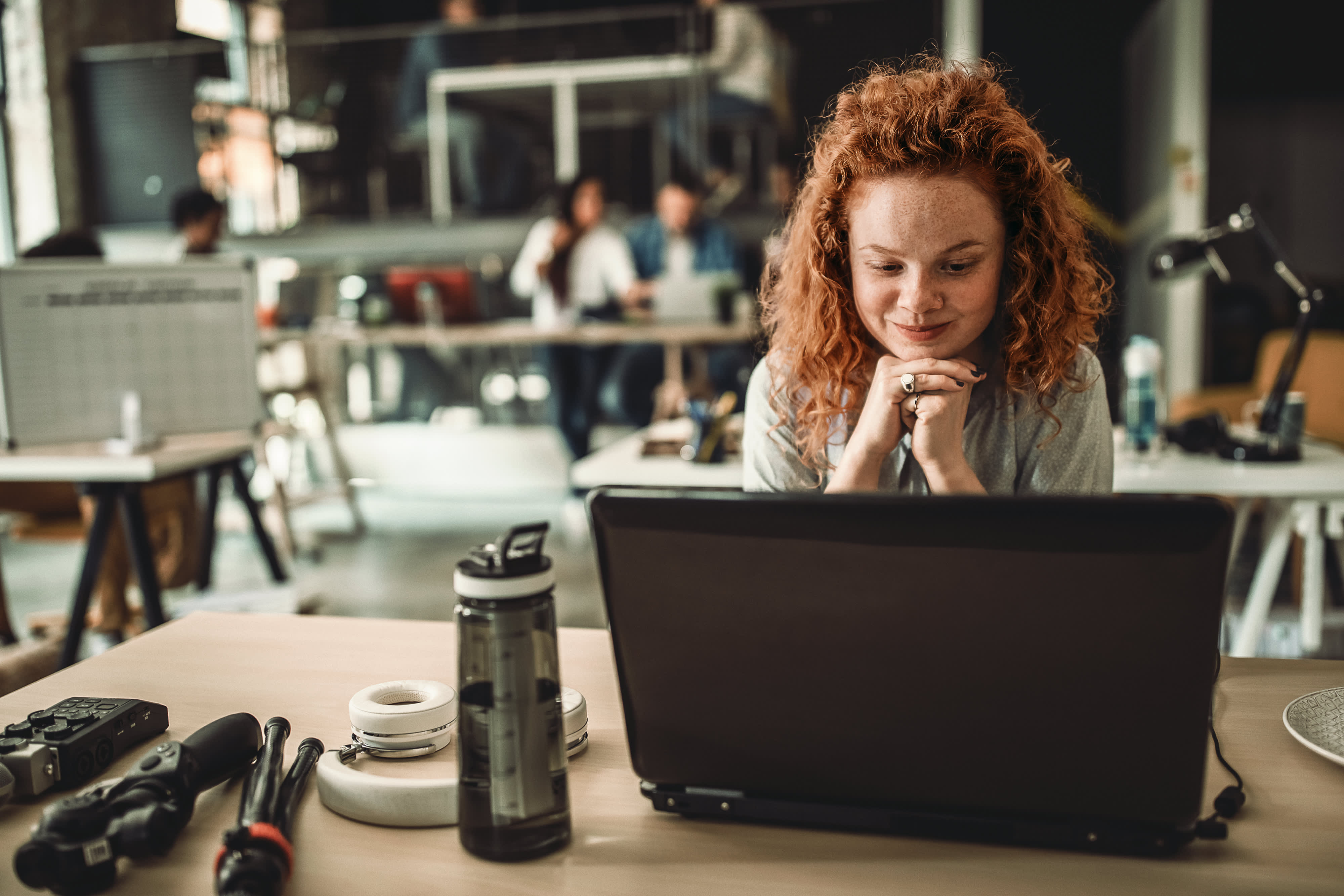 Titelbild für Infoseite “Bachelor New Work”: New Work Studentin arbeitet am Laptop im Büro
