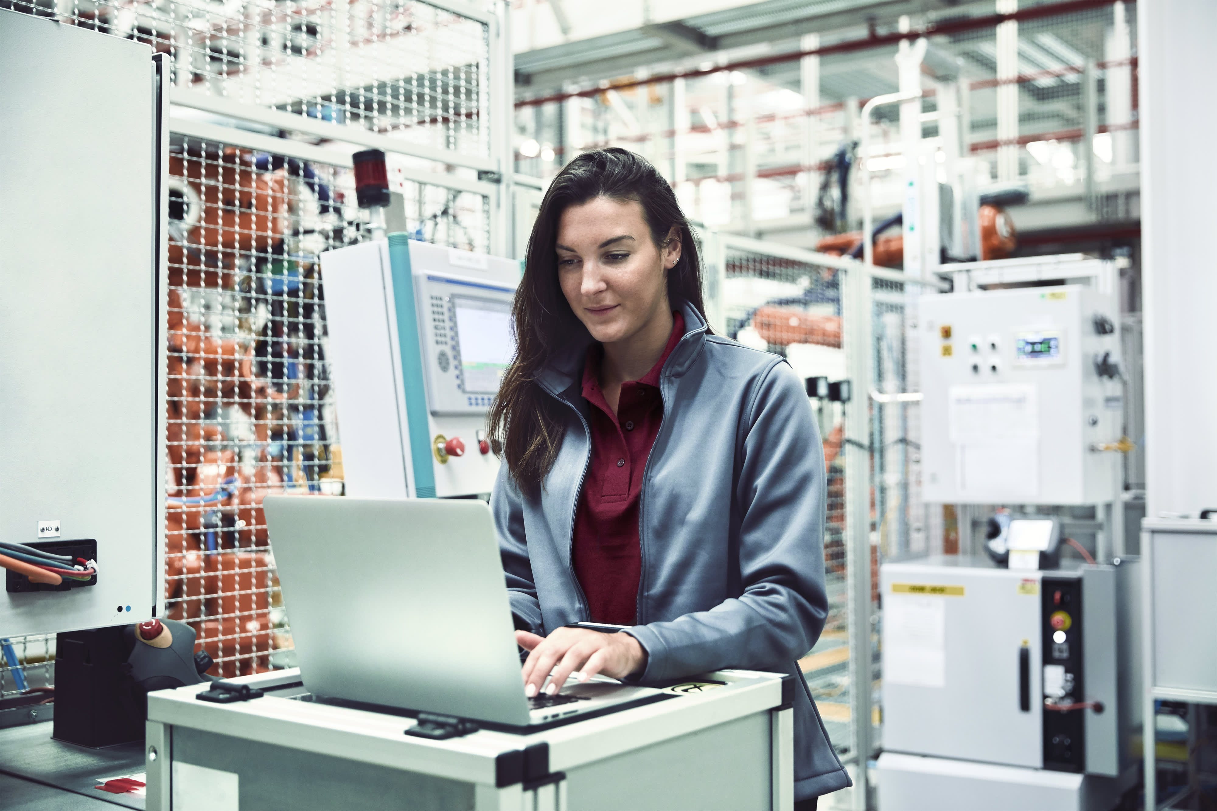 Titelbild für Infoseite “Bachelor Wirtschaftsingenieurwesen Industrie 4.0”: Ingenieurin mit Laptop in der Automobilindustrie