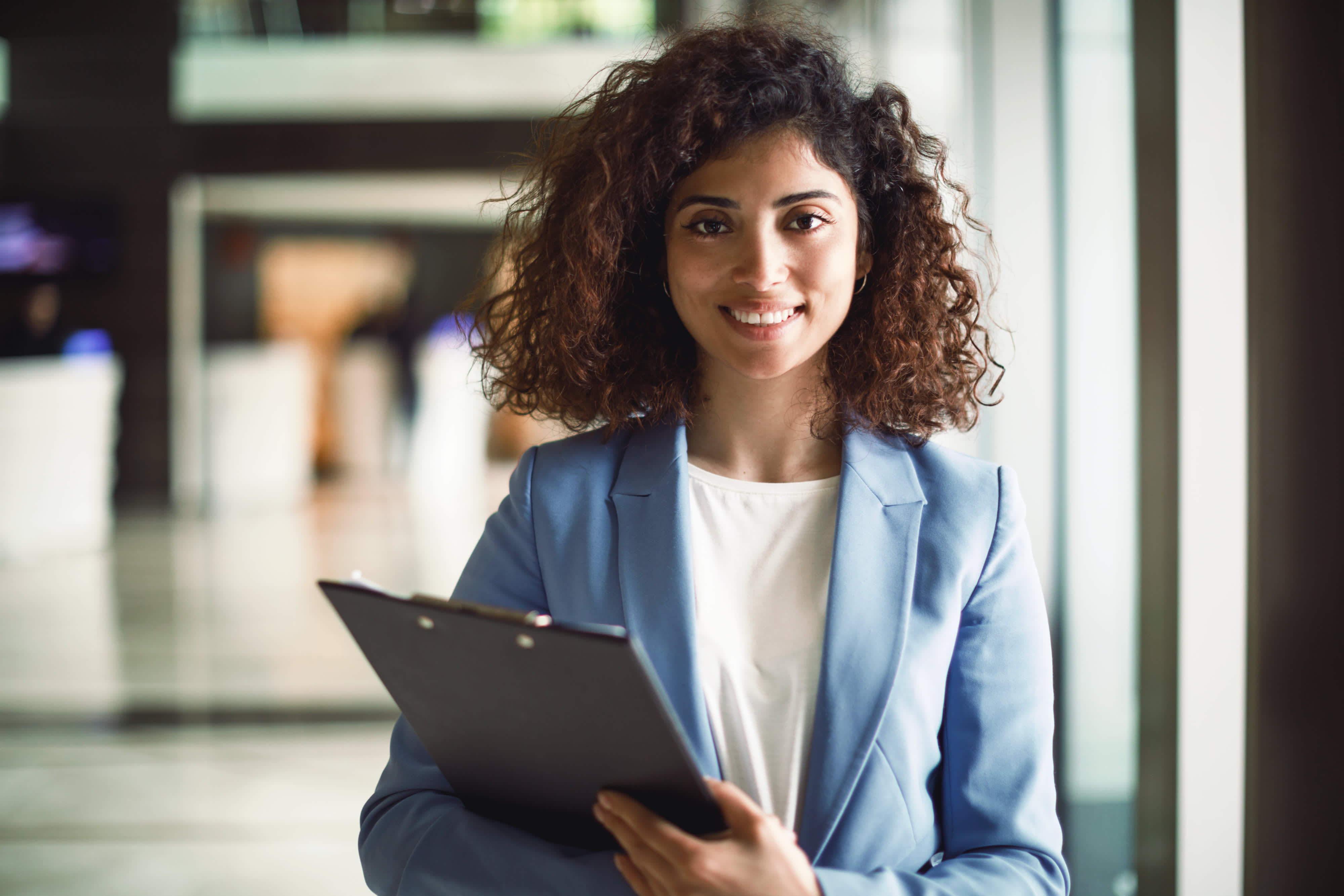 Titelbild für Infoseite “Master International Manager”: Managerin mit Klemmbrett vor Büro