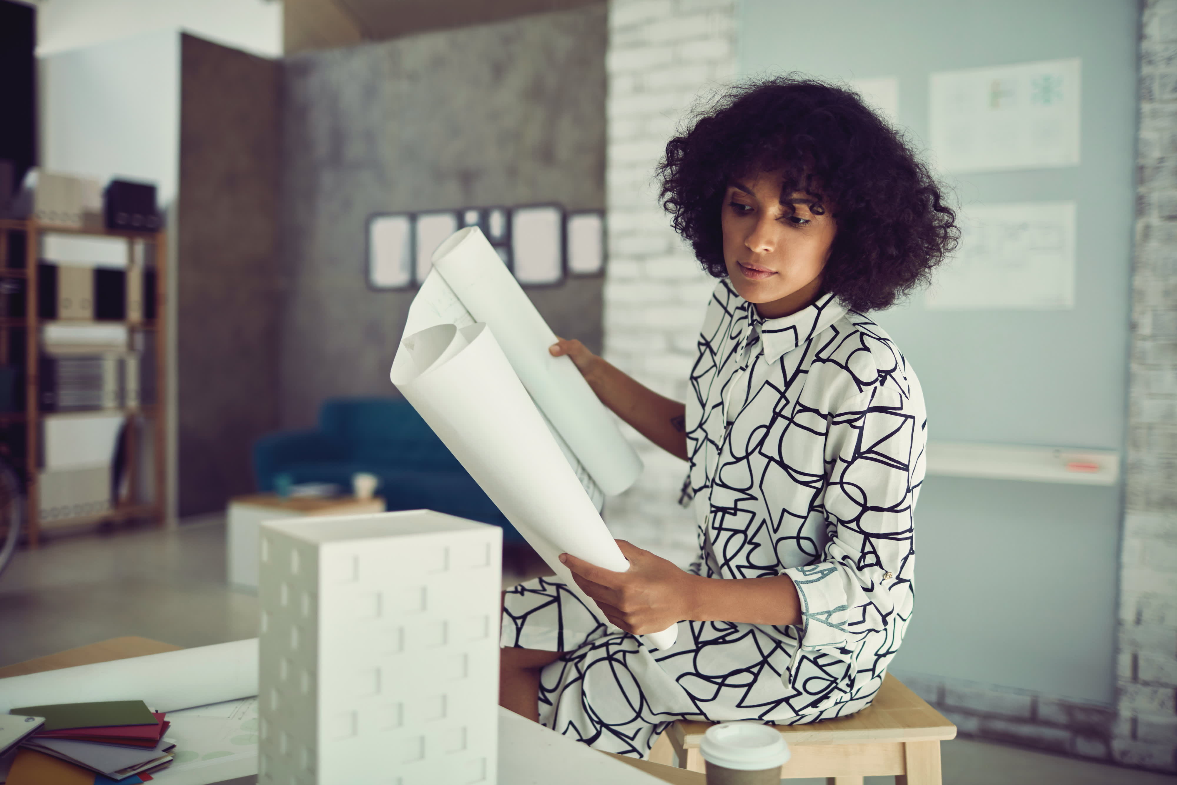 Titelbild für Infoseite “Bachelor Architektur”: Studentin arbeitet an Bau-Modell