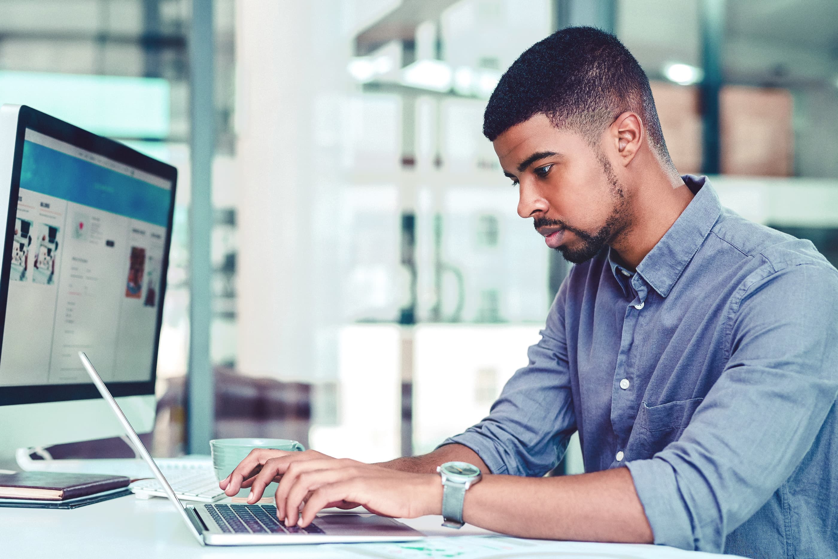 Titelbild für Infoseite: "duales Studium Wirtschaft und Management": Mann arbeitet am Laptop am Schreibtisch