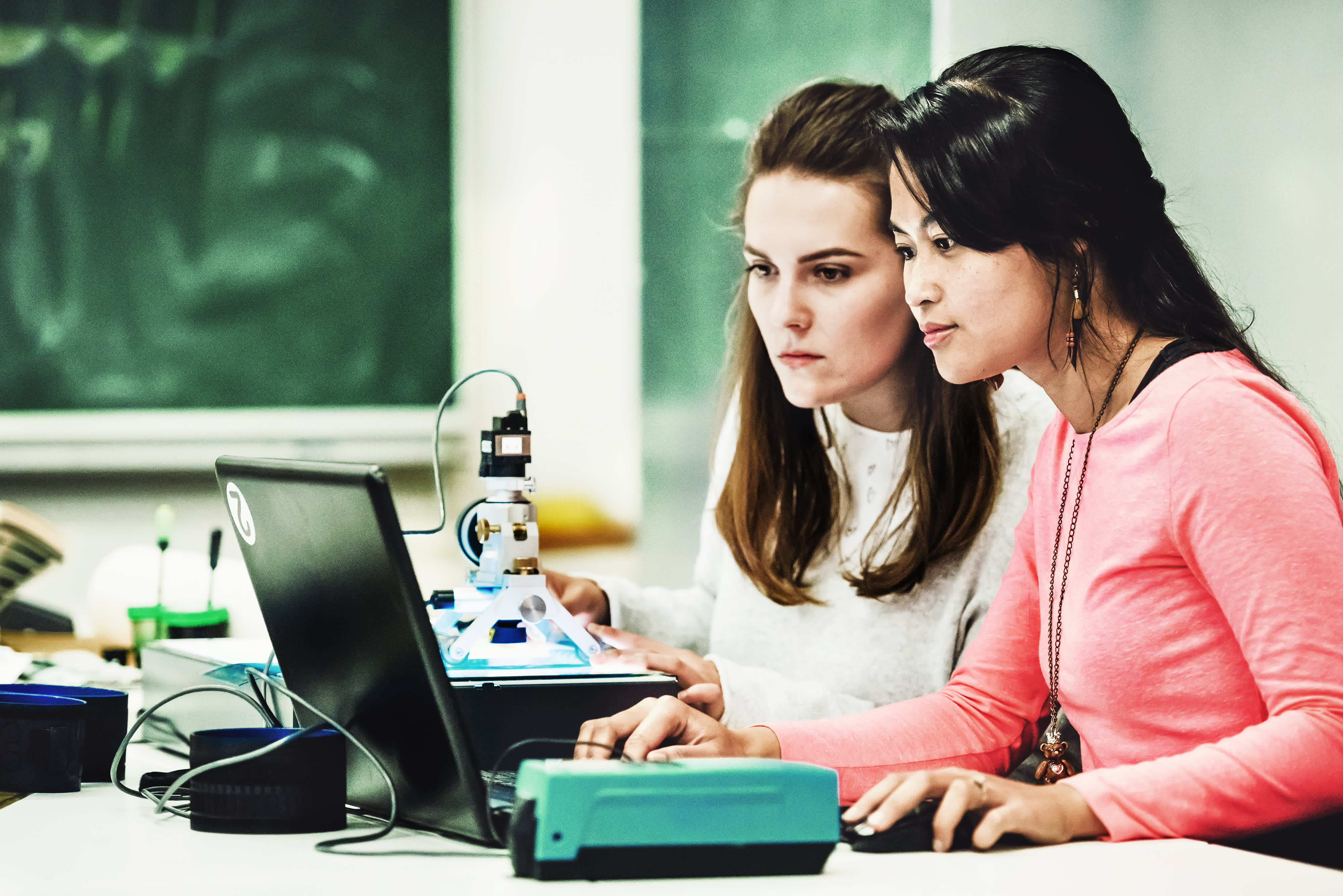 Zwei Studentinnen, die sich bei der Arbeit am Computer auf ein Experiment konzentrieren