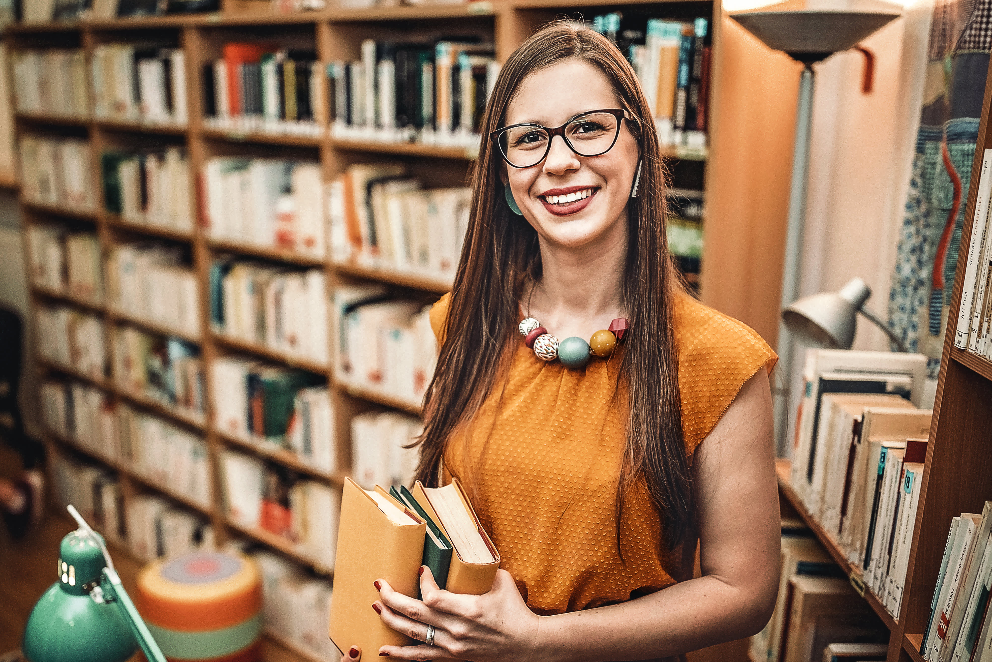 Titelbild zur Infoseite "Forschung an der IU": Frau in Bibliothek