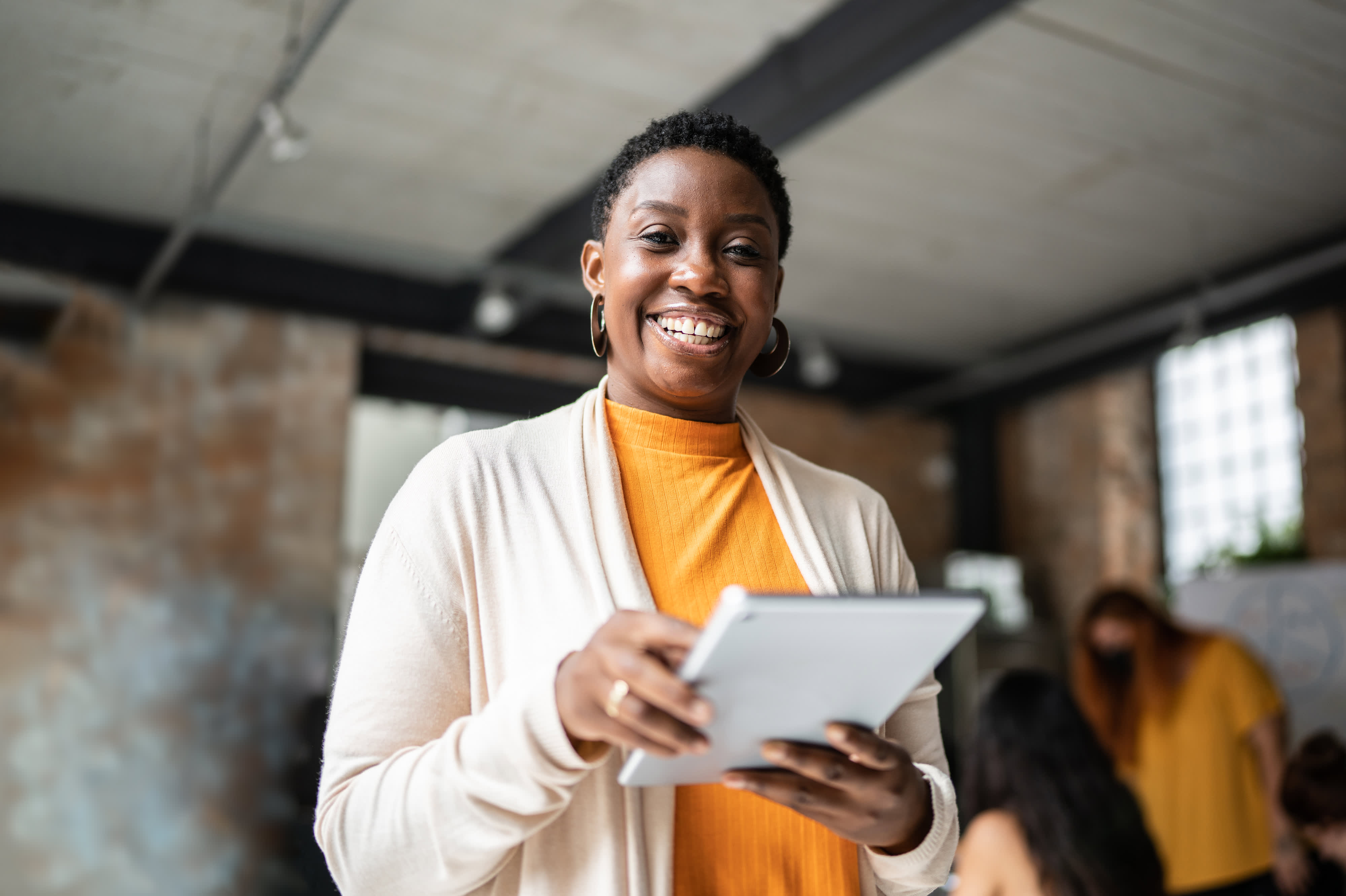 Titelbild für Infoseite “Bachelor Online Marketing”: Online Marketing Managerin arbeitet mit Tablet in Büro