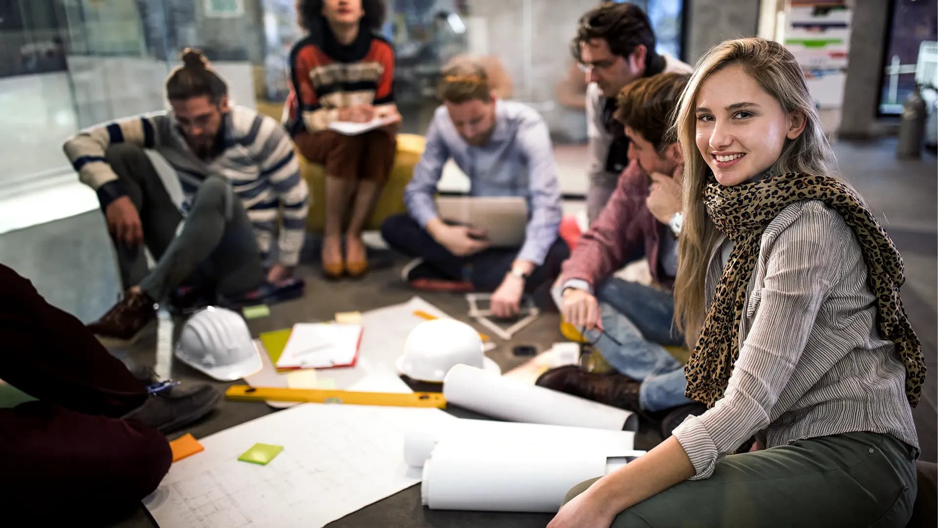 Titelbild zum Artikel "Rechte als Werkstudent:in": Studierende und Kollegen sitzen im Kreis im Büro