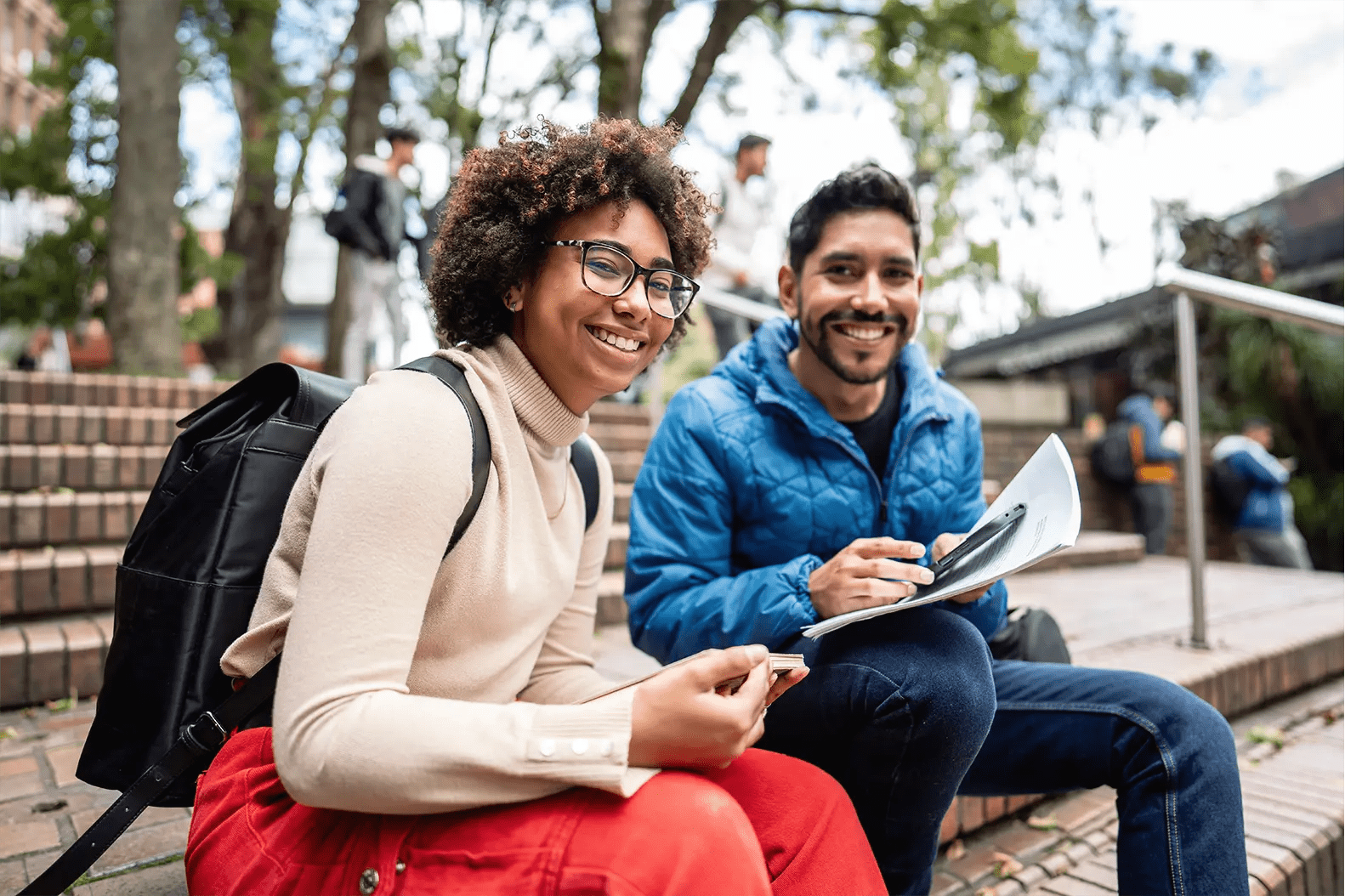 Titelbild zur Infoseite "Studium und Ausbildung": Zwei Studierende sitzen draußen am Campus