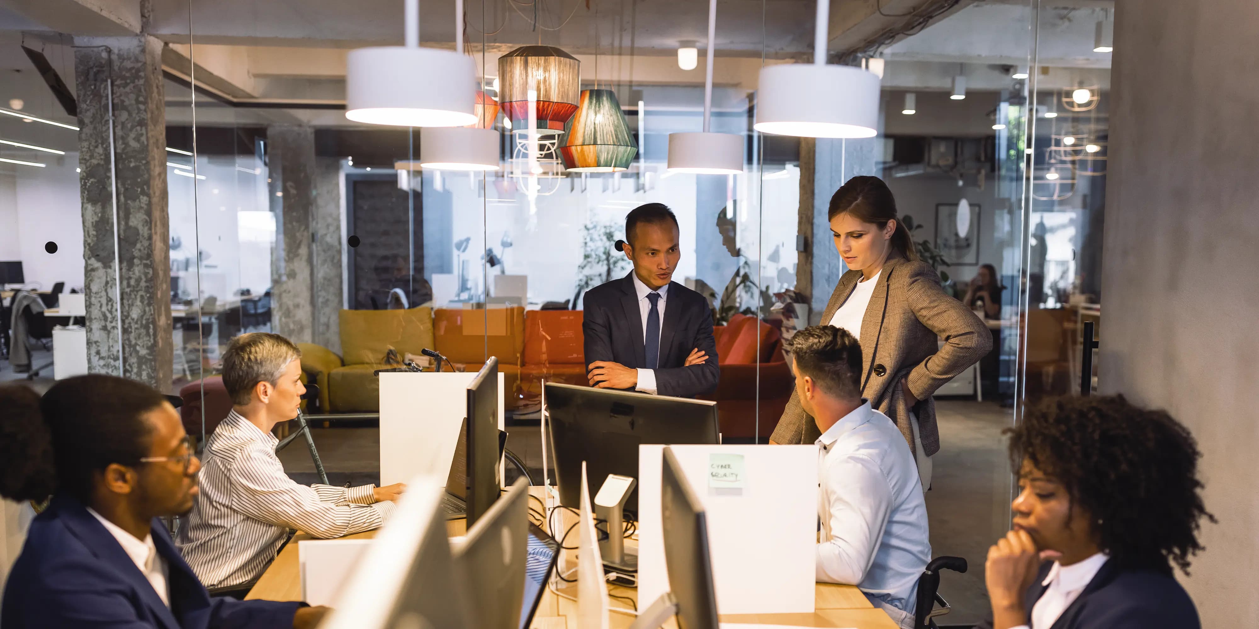 Titelbild der Infoseite "Fernstudium Sicherheitsmanagement": Studierendehaben eine Besprechung in einem Meeting Raum
