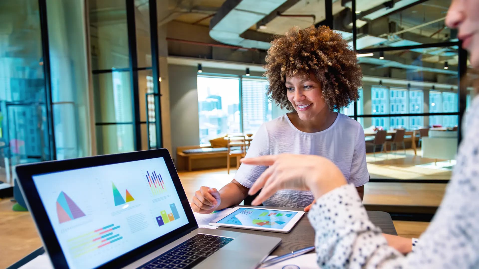 Titelbild für den Artikel "Was ist quantitative Forschung?": Zwei Personen schauen auf einen Laptop mit Grafiken