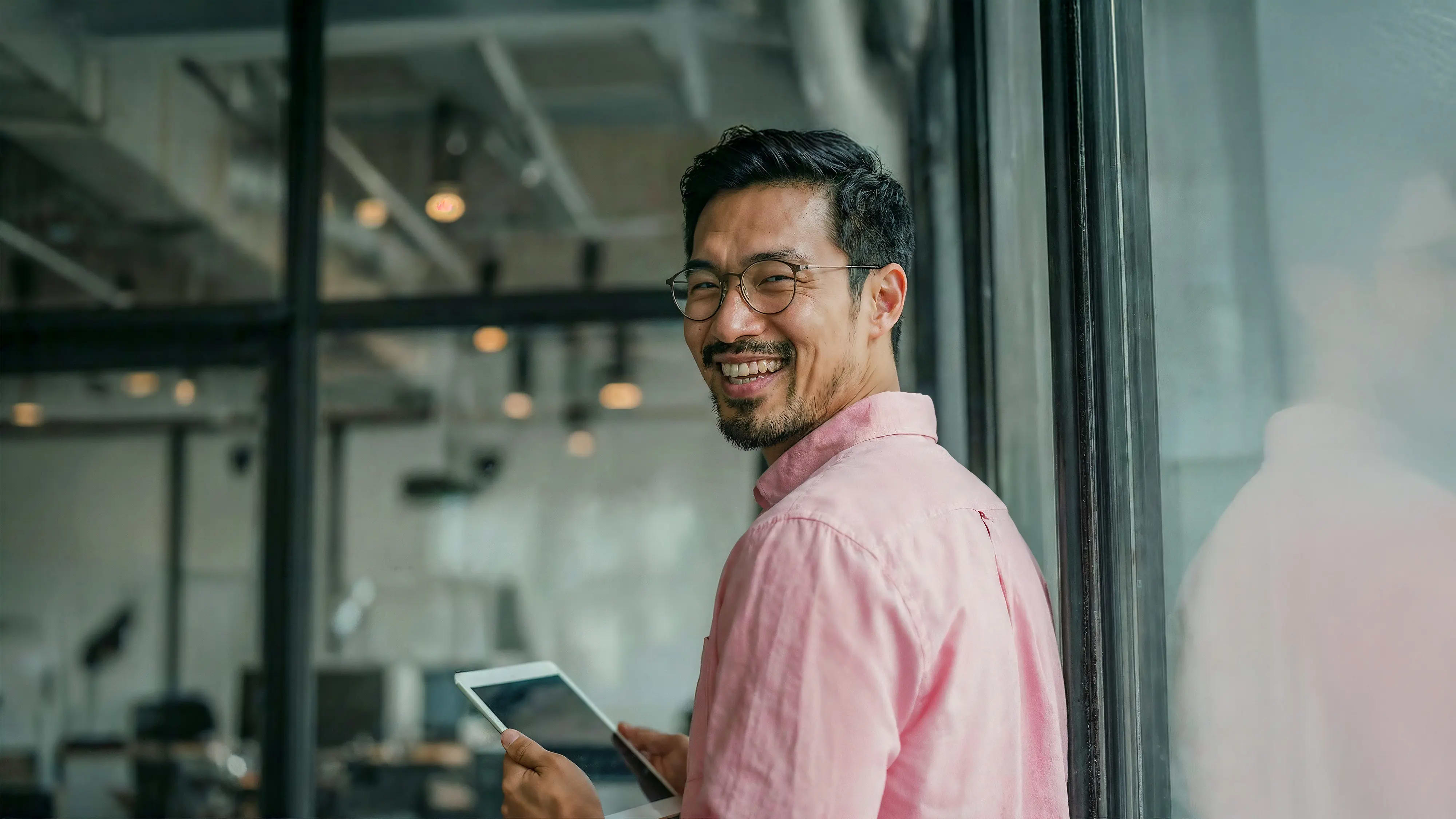 Bachelor Wirtschaftsrecht: Mann mit Tablet in der Hand steht vor Büro