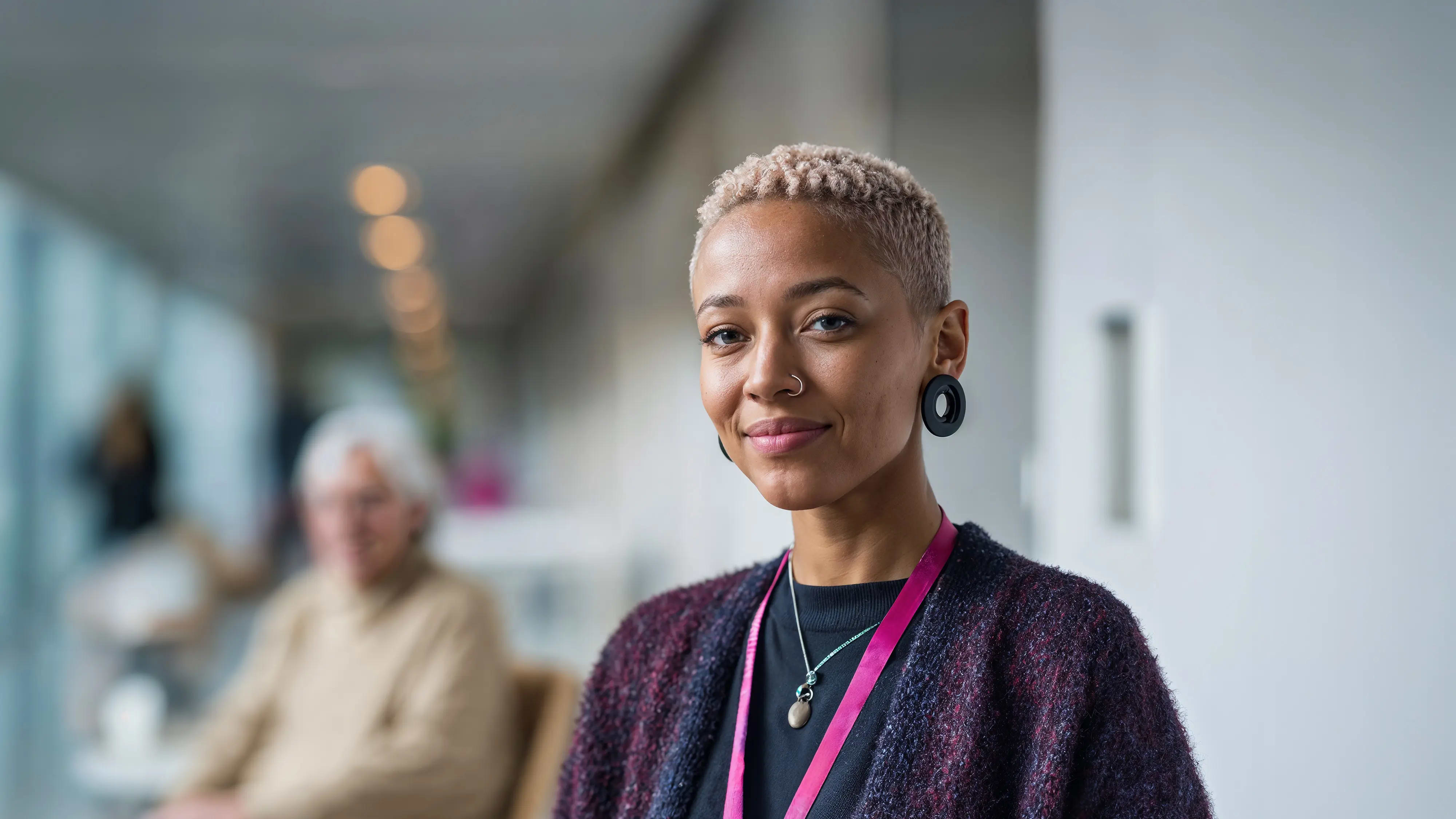 Bachelor Gesundheitsmanagement: Frau steht im Flur einer Gesundheitseinrichtung