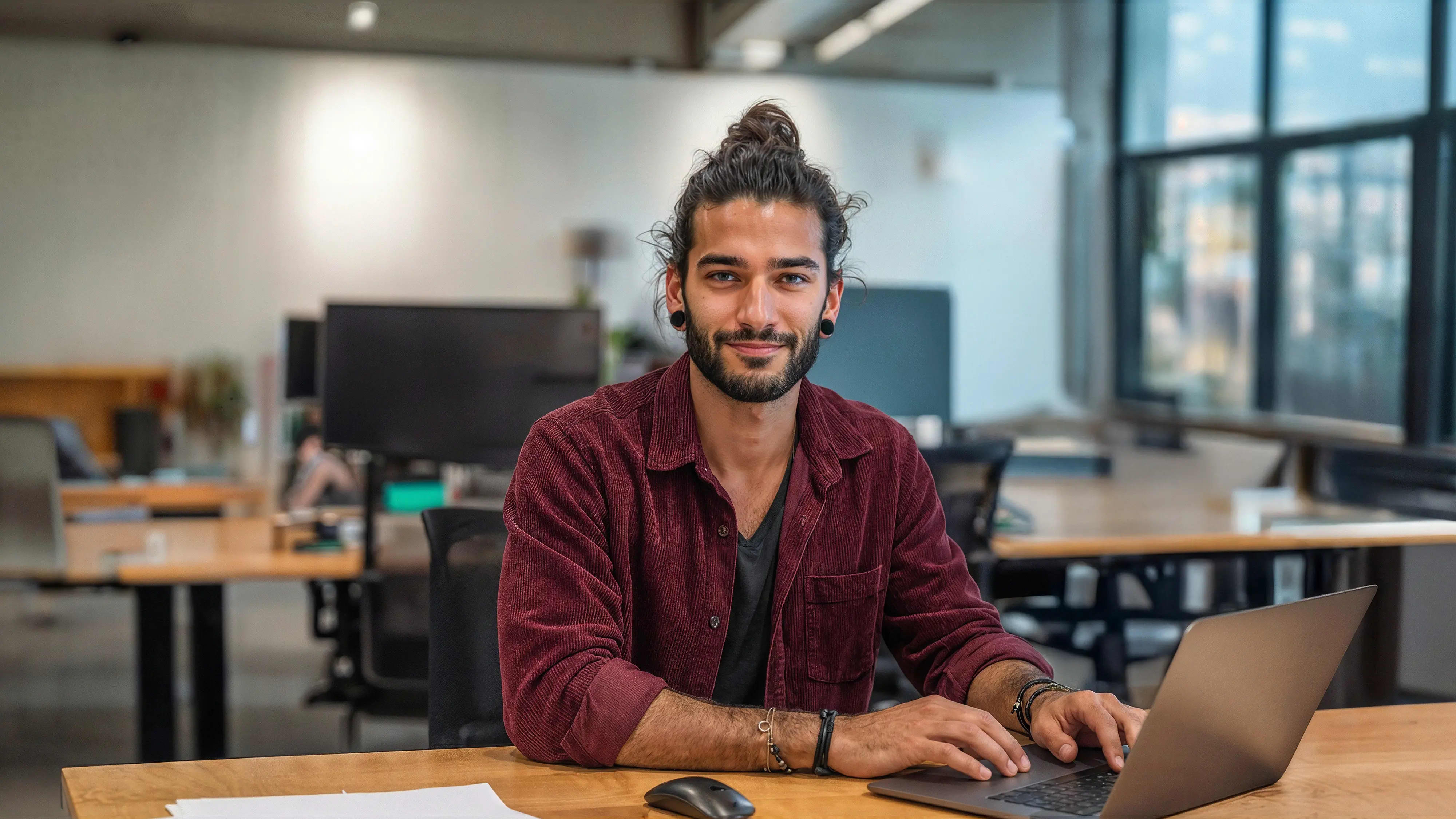 Bachelor Marketing: Mann sitze am Laptop in grossem Büro
