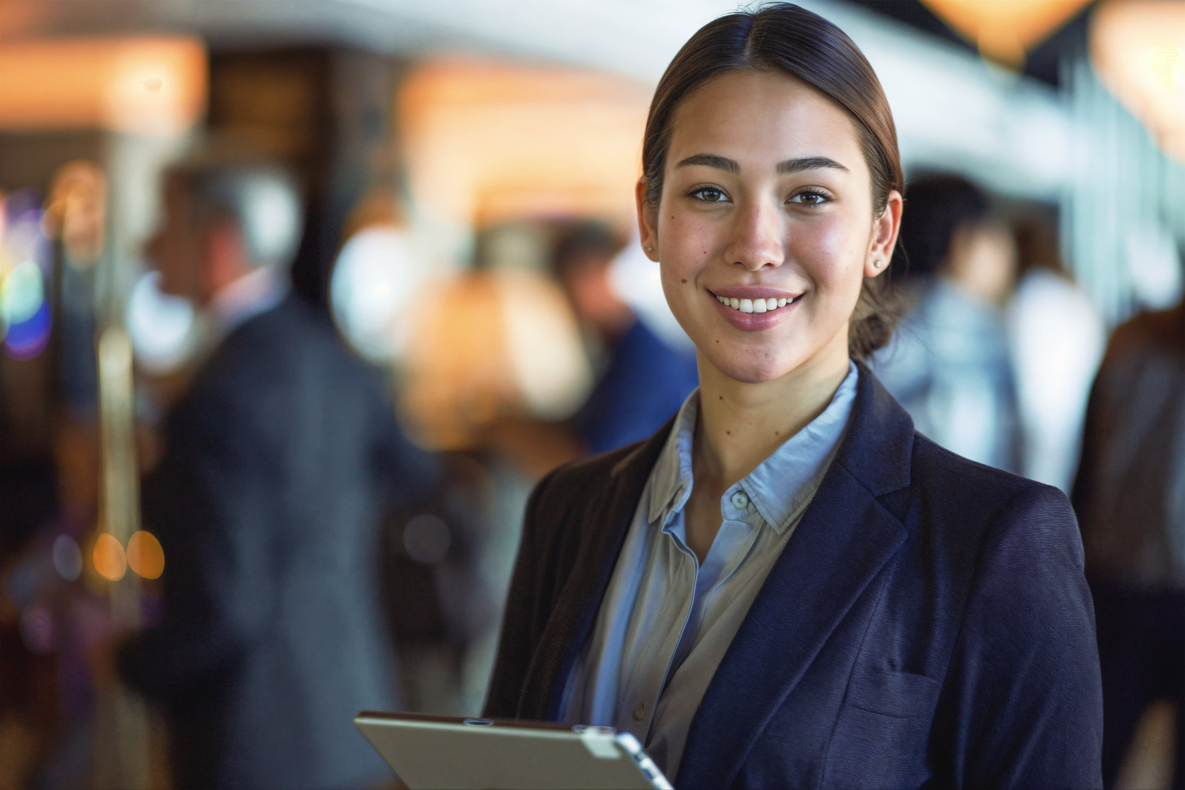 Titelbild der Infoseite "Duales Studium Eventmanagement Hamburg": Junge Frau ist förmlich gekleidet und hält ein Tablet in der Hand