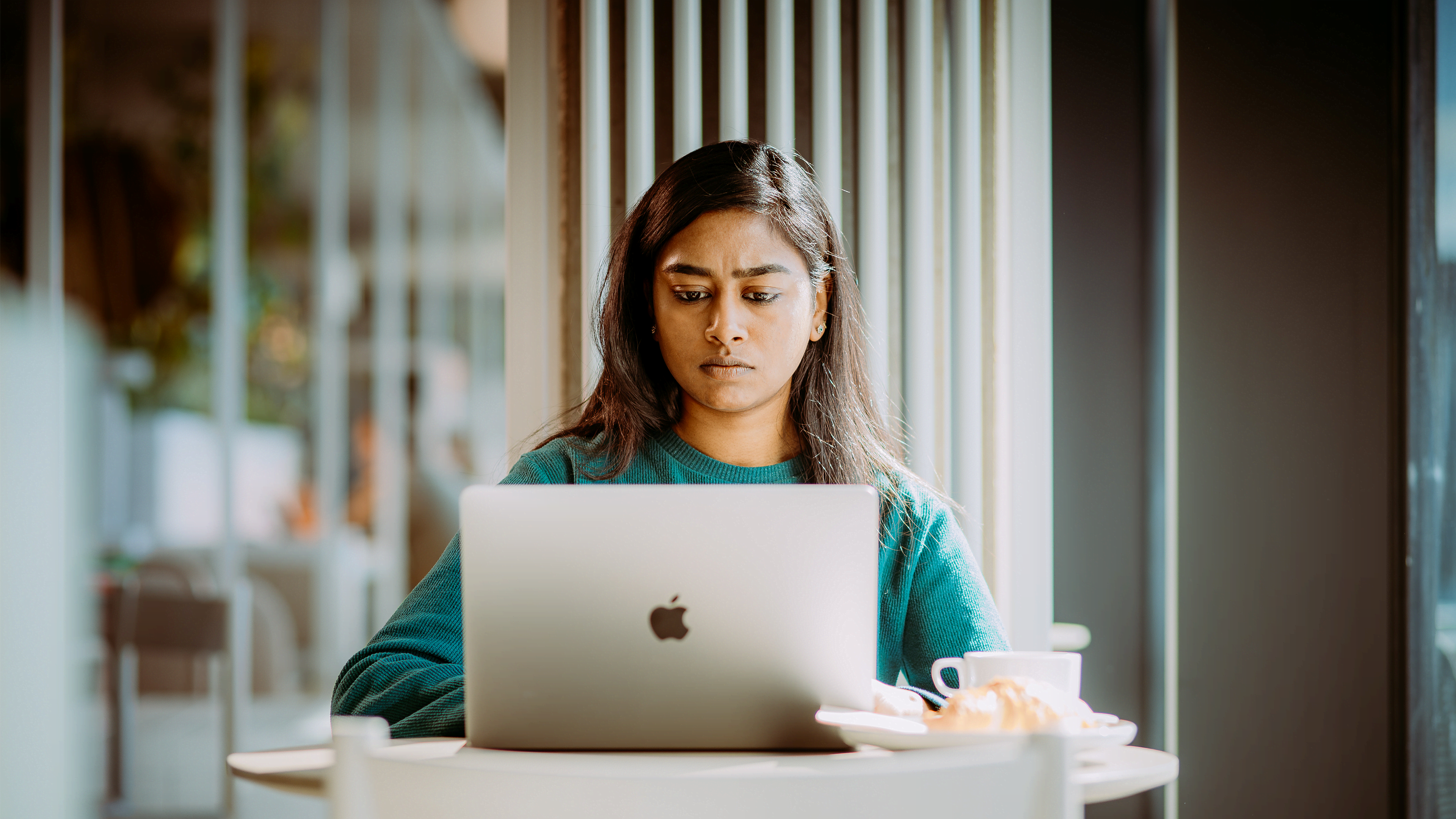 A young woman studying at a coffee shop in Germany for a degree in Computer Science