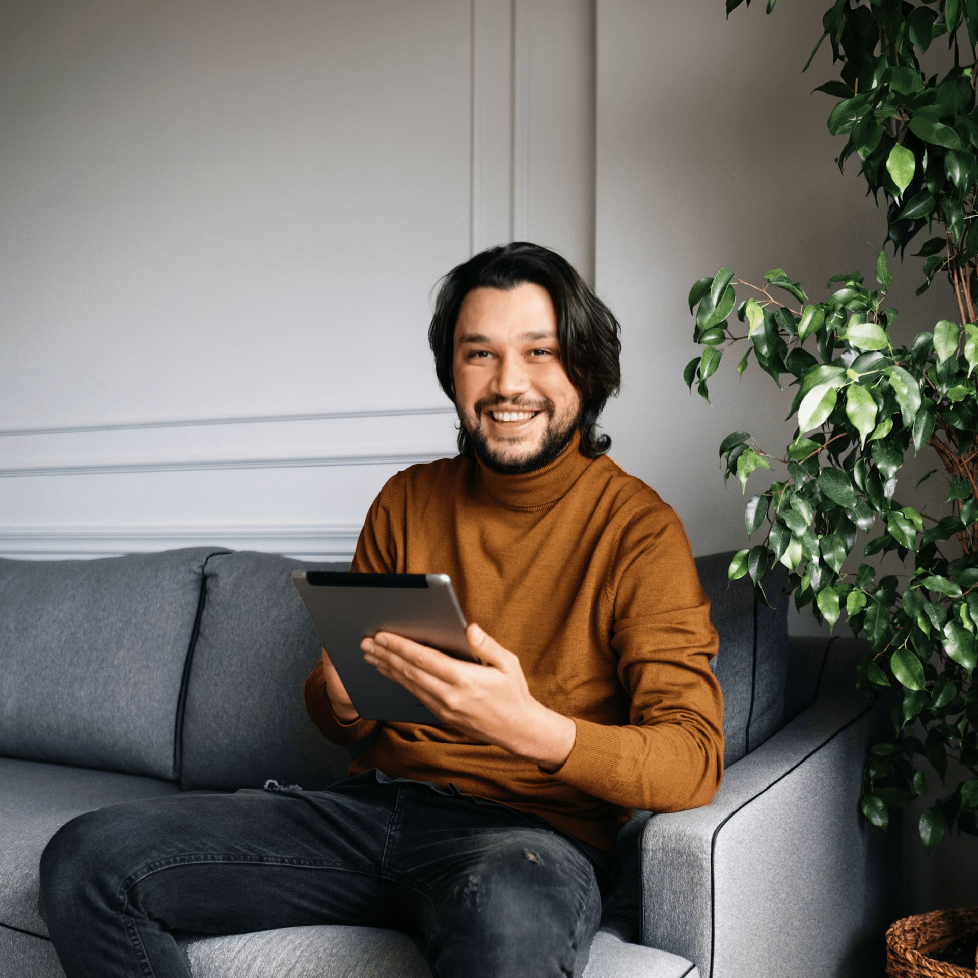 Man sitting on sofa reading ipad