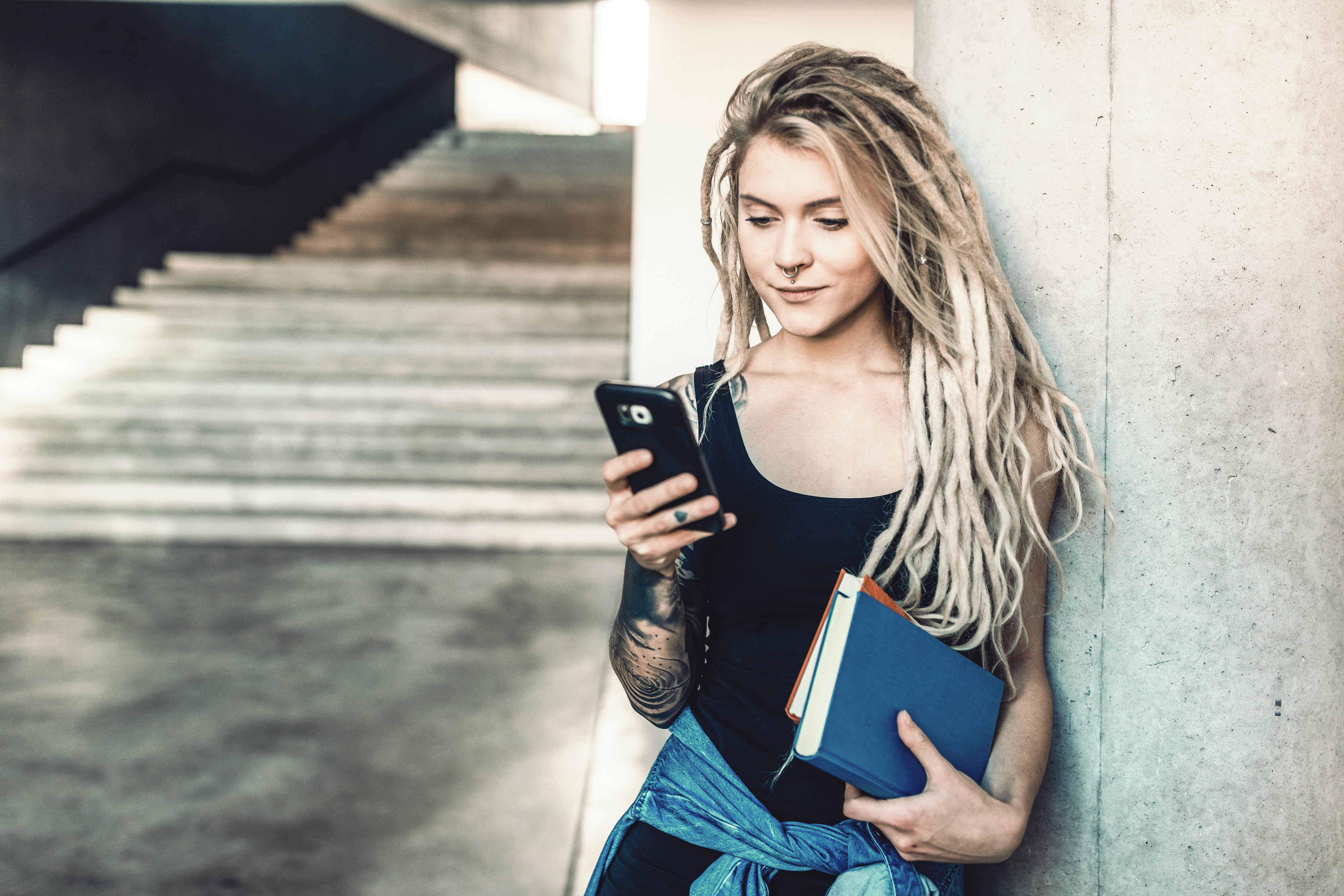 Titelbild für Artikel “Digital Detox”: Studentin informiert sich an ihrem Smartphone über die Möglichkeiten von Digital Detox