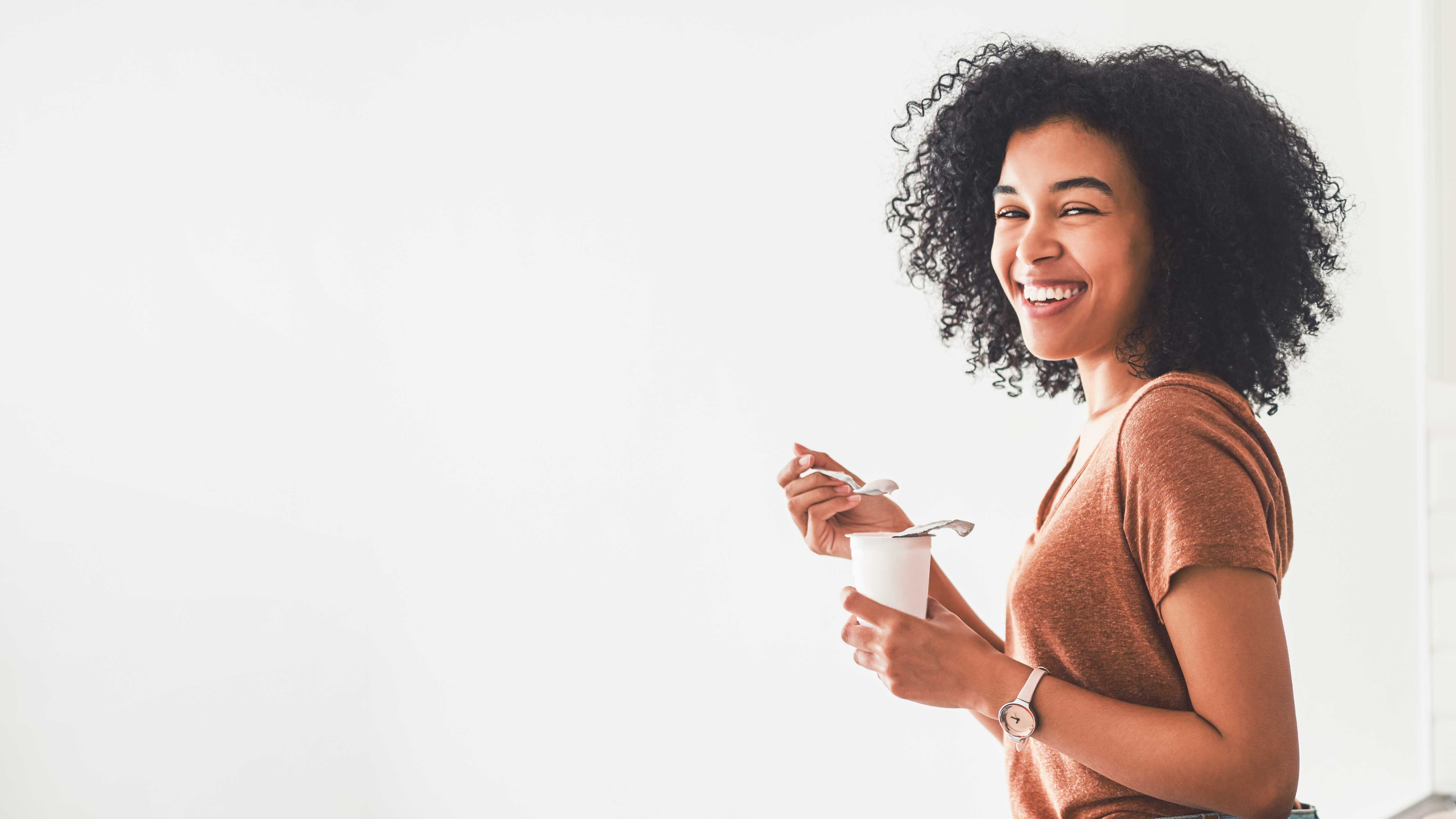 Titelbild zum Artikel "Gesunde Ernährung für Studierende": Studentin isst Joghurt
