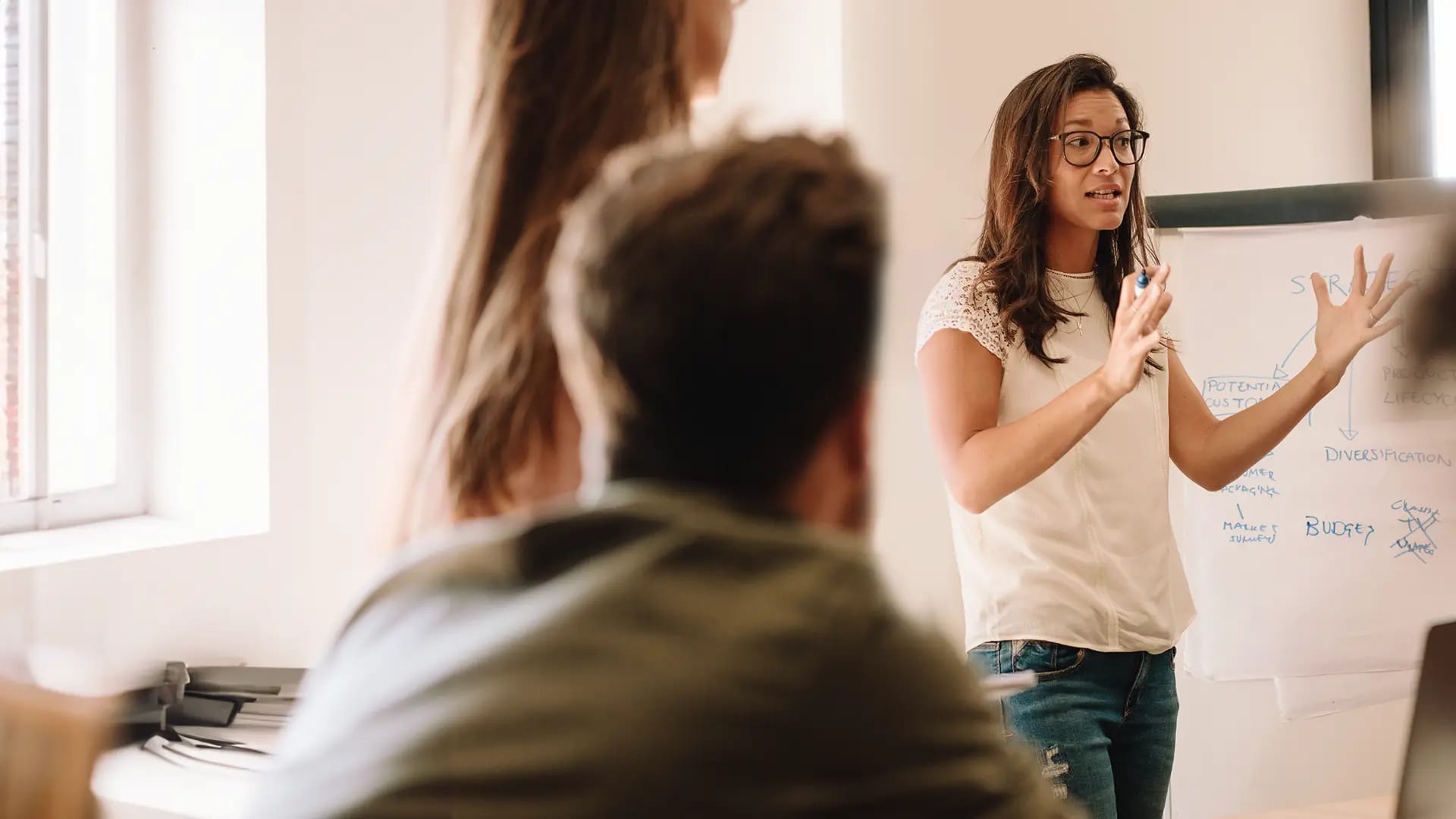 Titelbild zum Artikel "Überzeugend präsentieren mit Rhetorik": Frau präsentiert vor Publikum