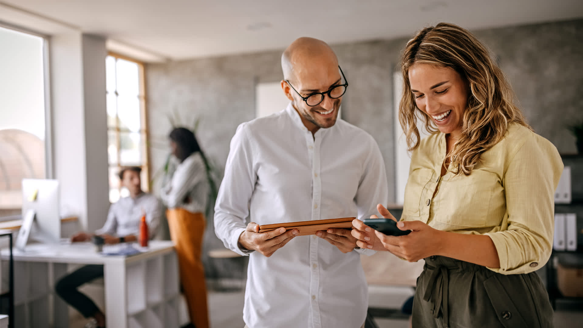 Male and female employee problem-solving a model development project in an office.