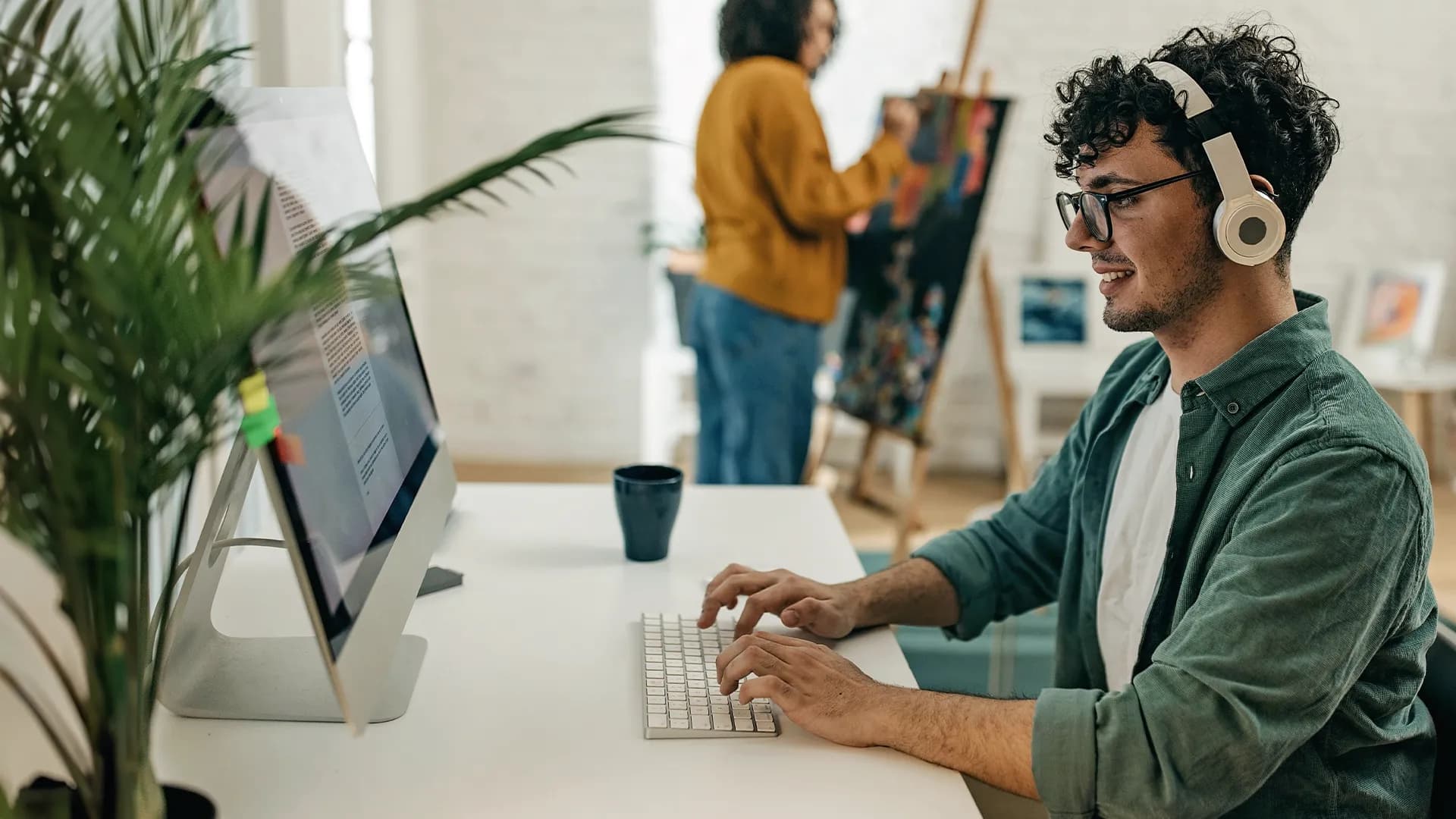 Titelbild für Artikel "Medienwissenschaften": Student mit Kopfhörern arbeitet am Laptop