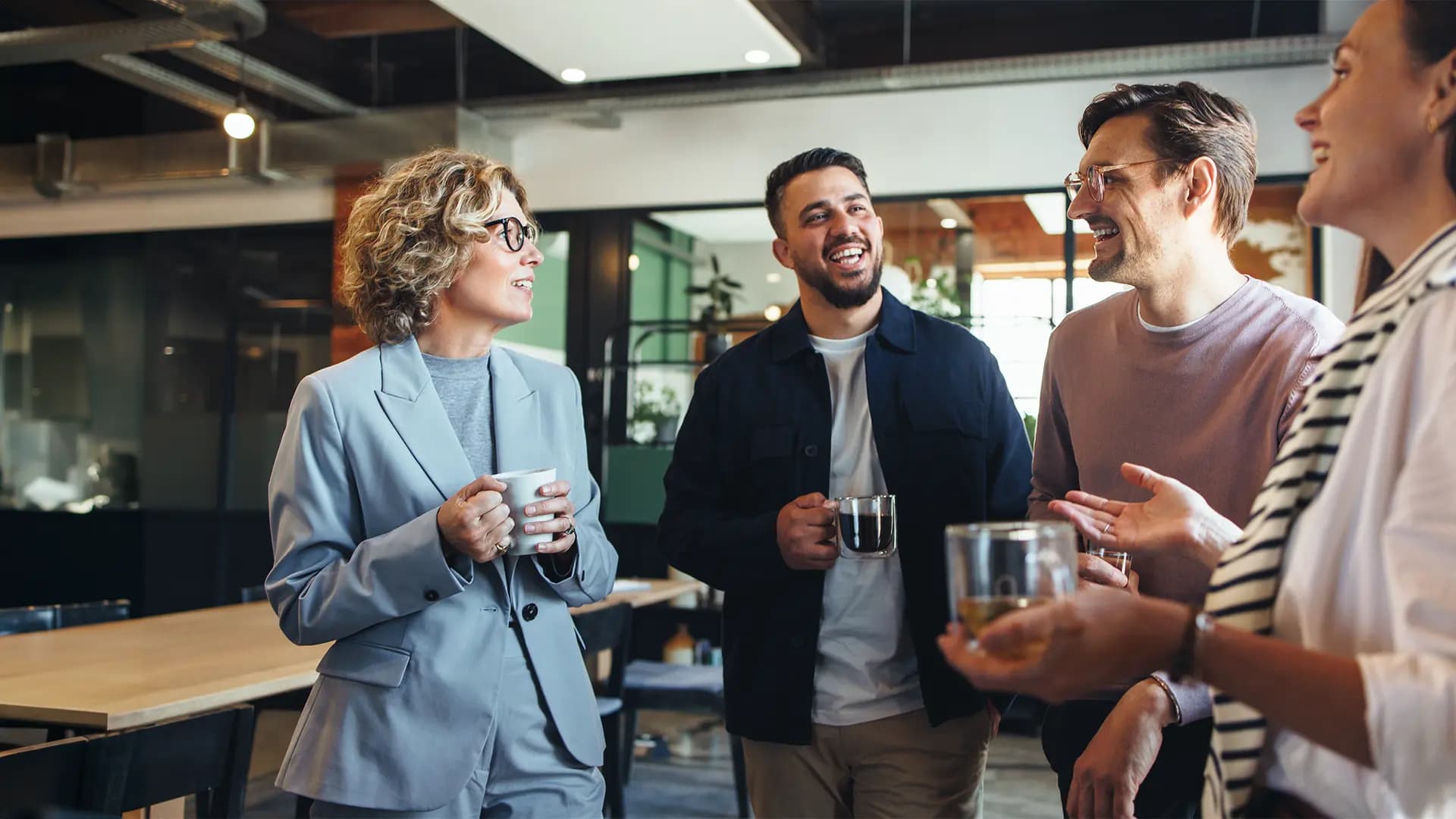 Titelbild zum Artikel "Networking Tipps": Gruppe Kollegen mit Tasse in der Hand unterhält sich