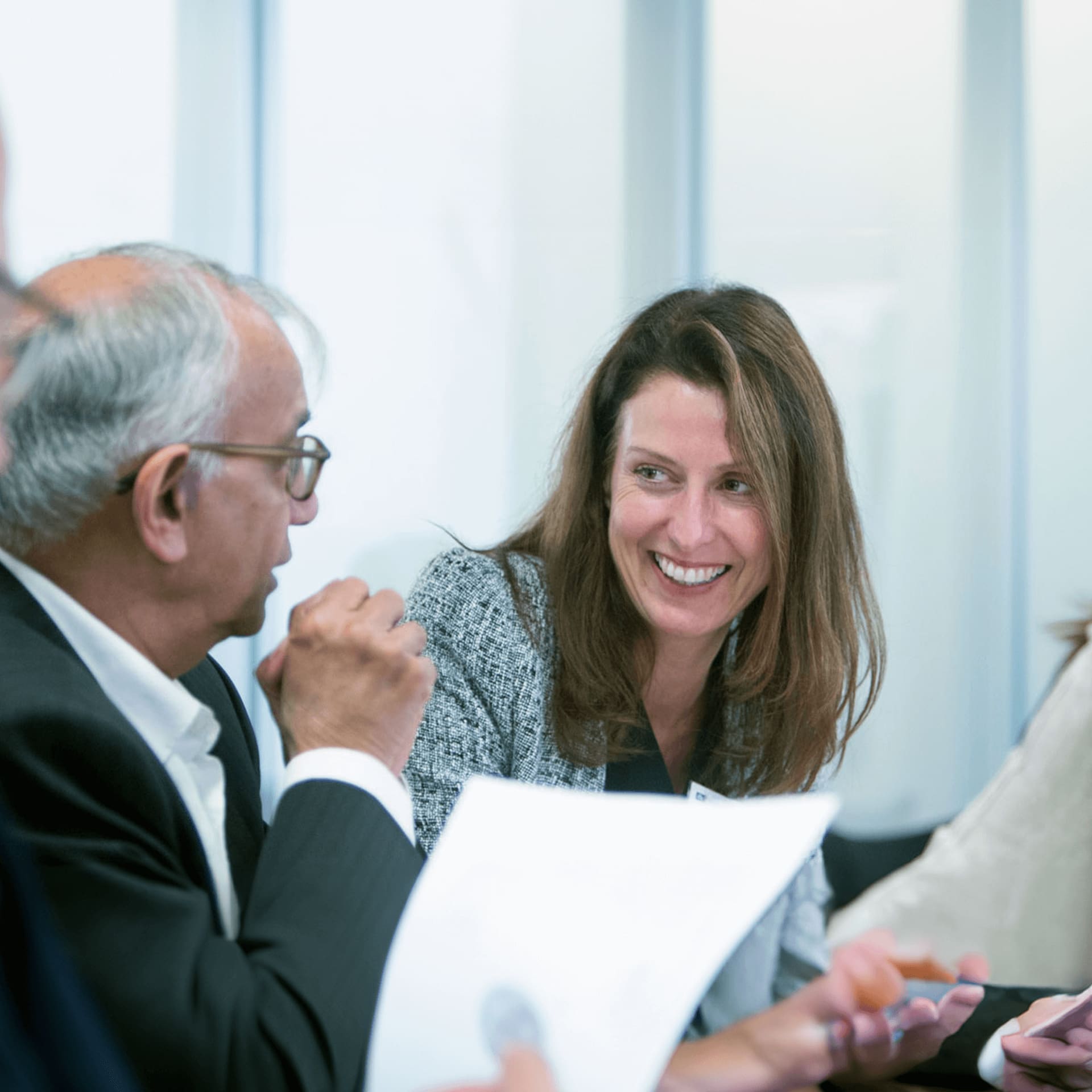 Two professionals in deep discussion about the CSDG at a trade event, the woman is smiling vibrantly at the man sat next to her.