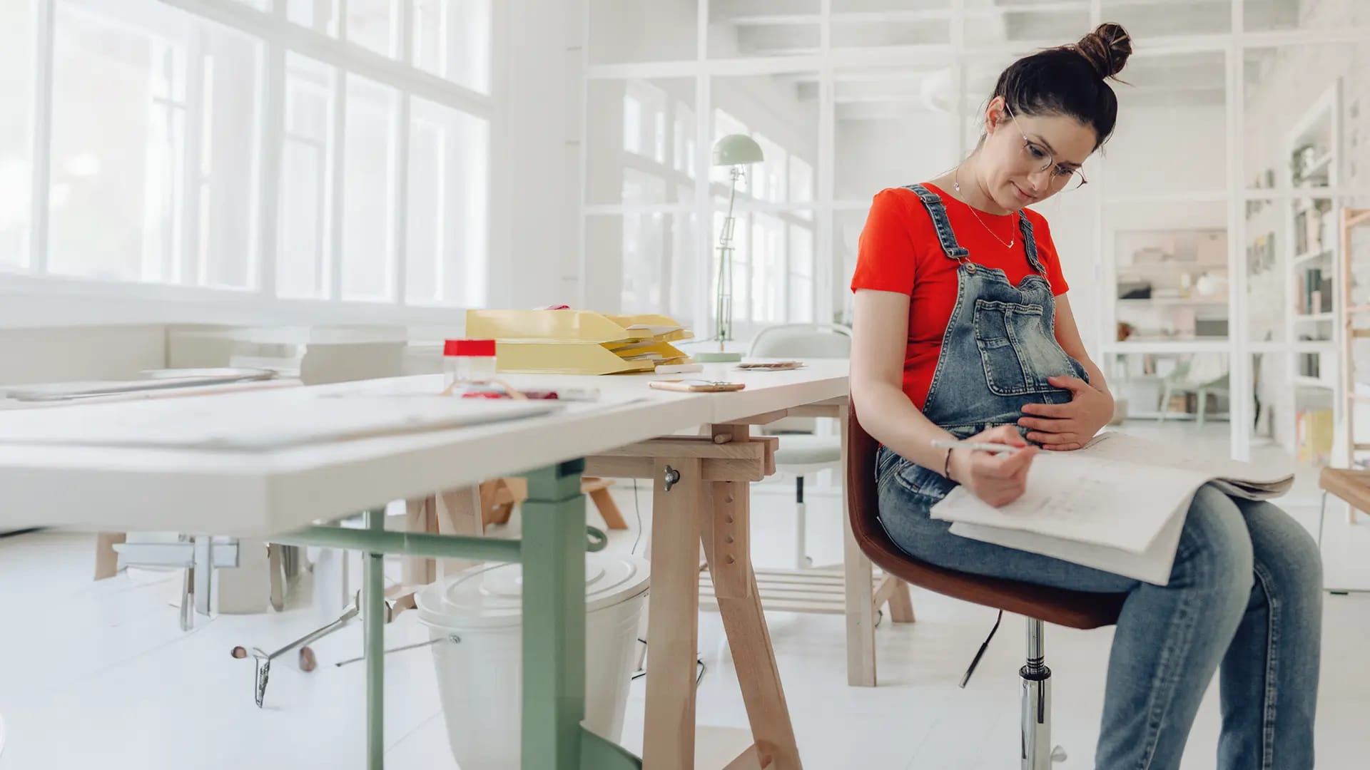 Titelbild für Artikel "Schwanger im Studium": Schwangere Studentin macht sich Notizen fürs Studium