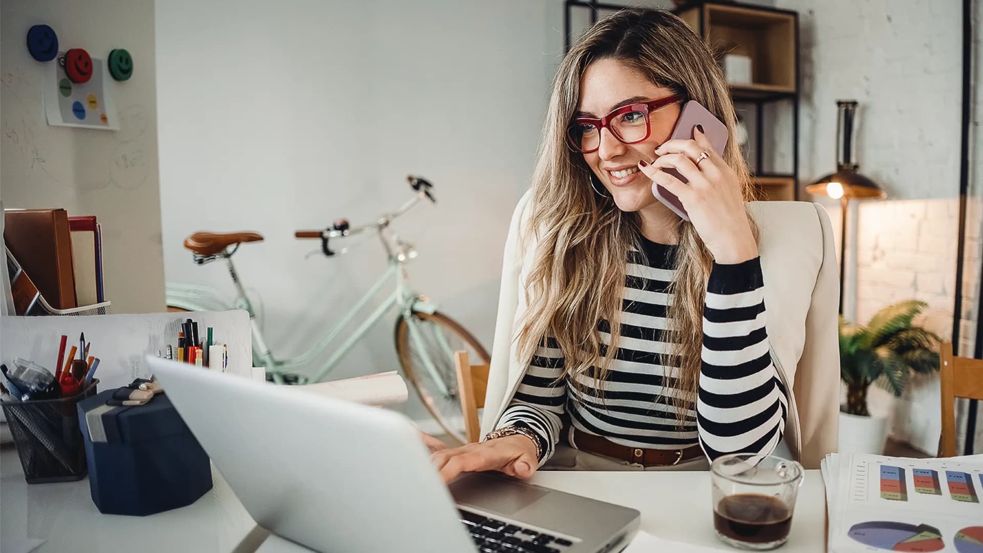 Studentin mit Laptop und Handy organisiert ihr Zeitmanagement
