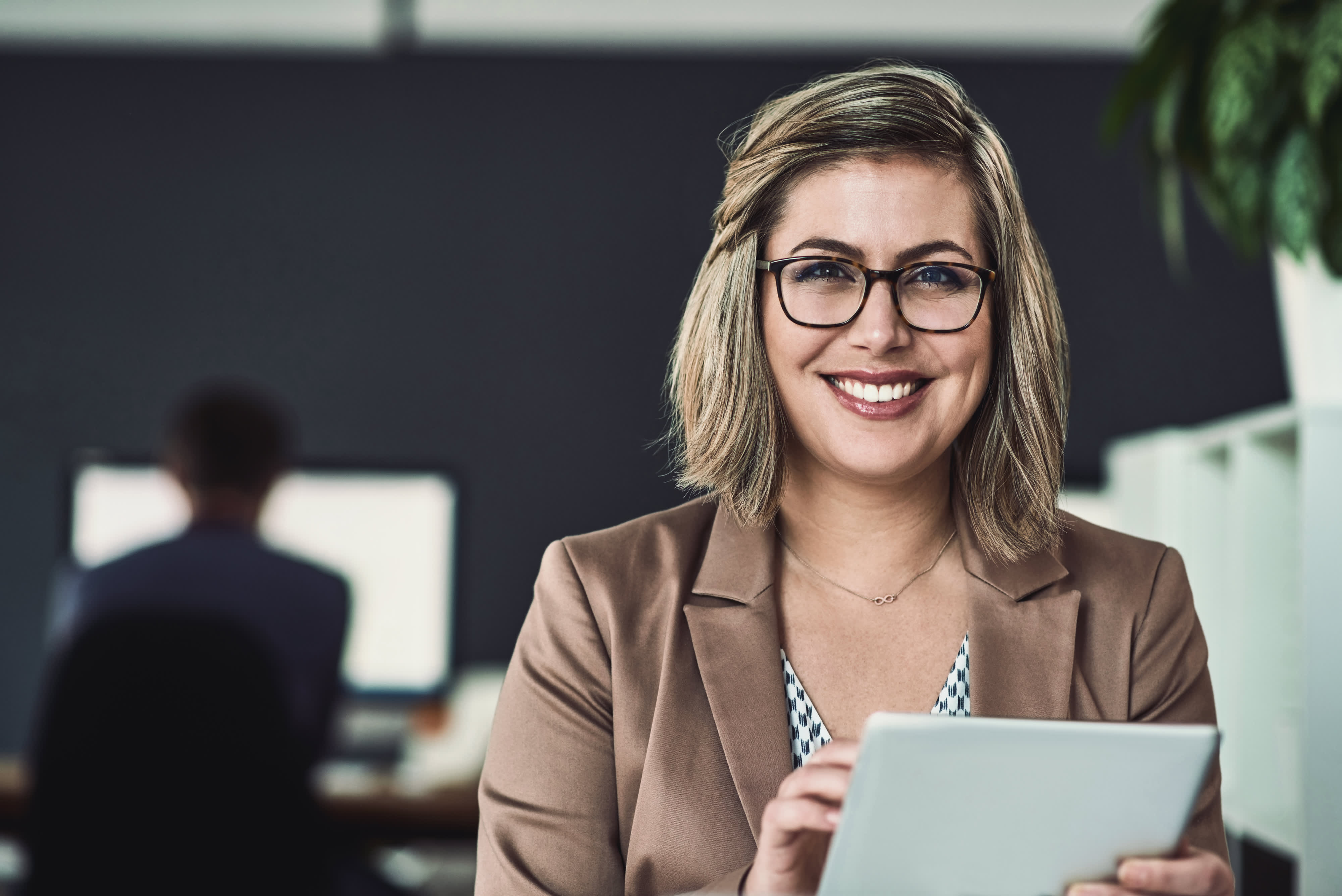 Titelbild für Infoseite “Bachelor Internationales Marketing”: Marketingmanager mit Tablet im Büro