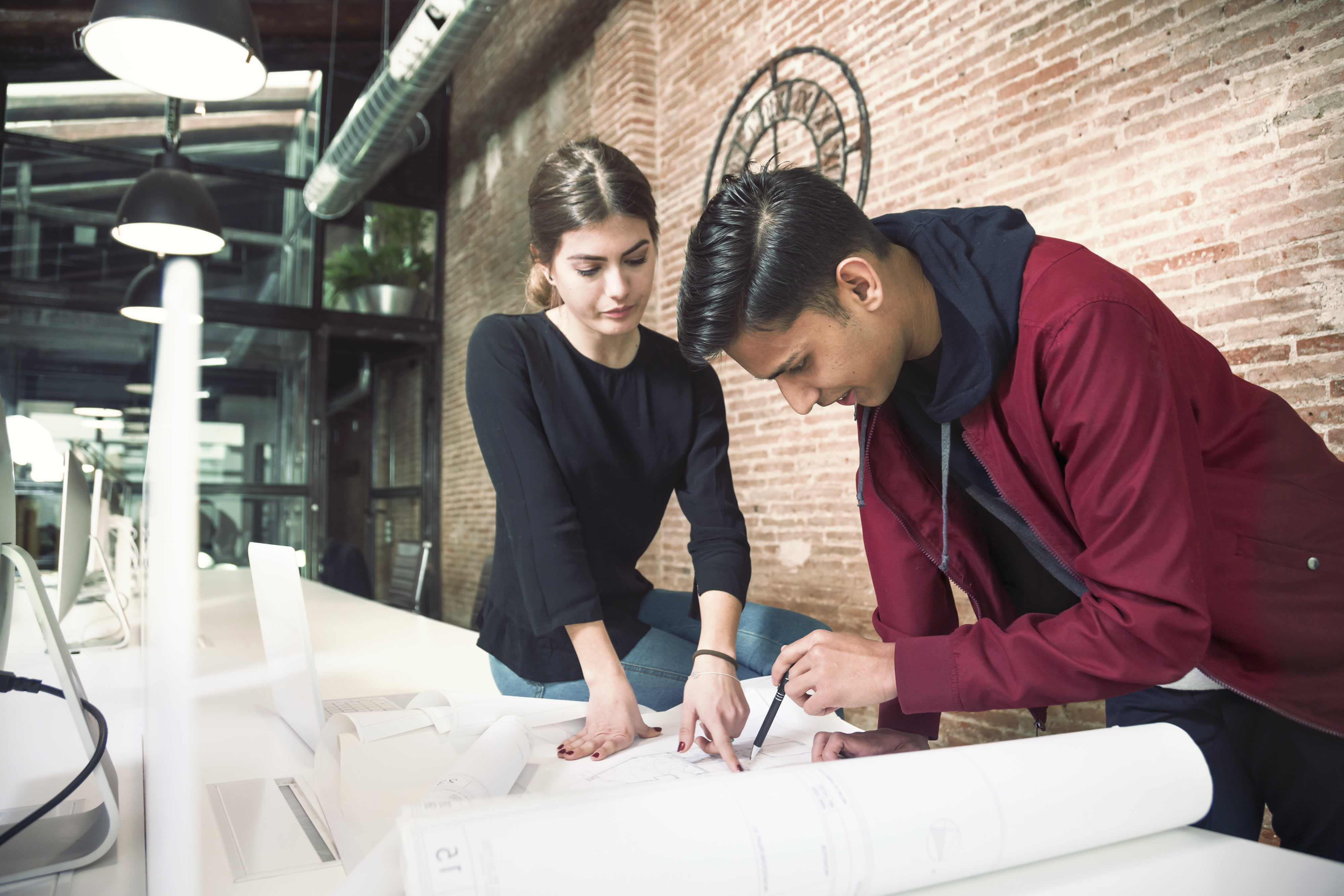 Titelbild für Infoseite “Bachelor Innenarchitektur”: Zwei Architektur-Studenten arbeiten an Bauplänen