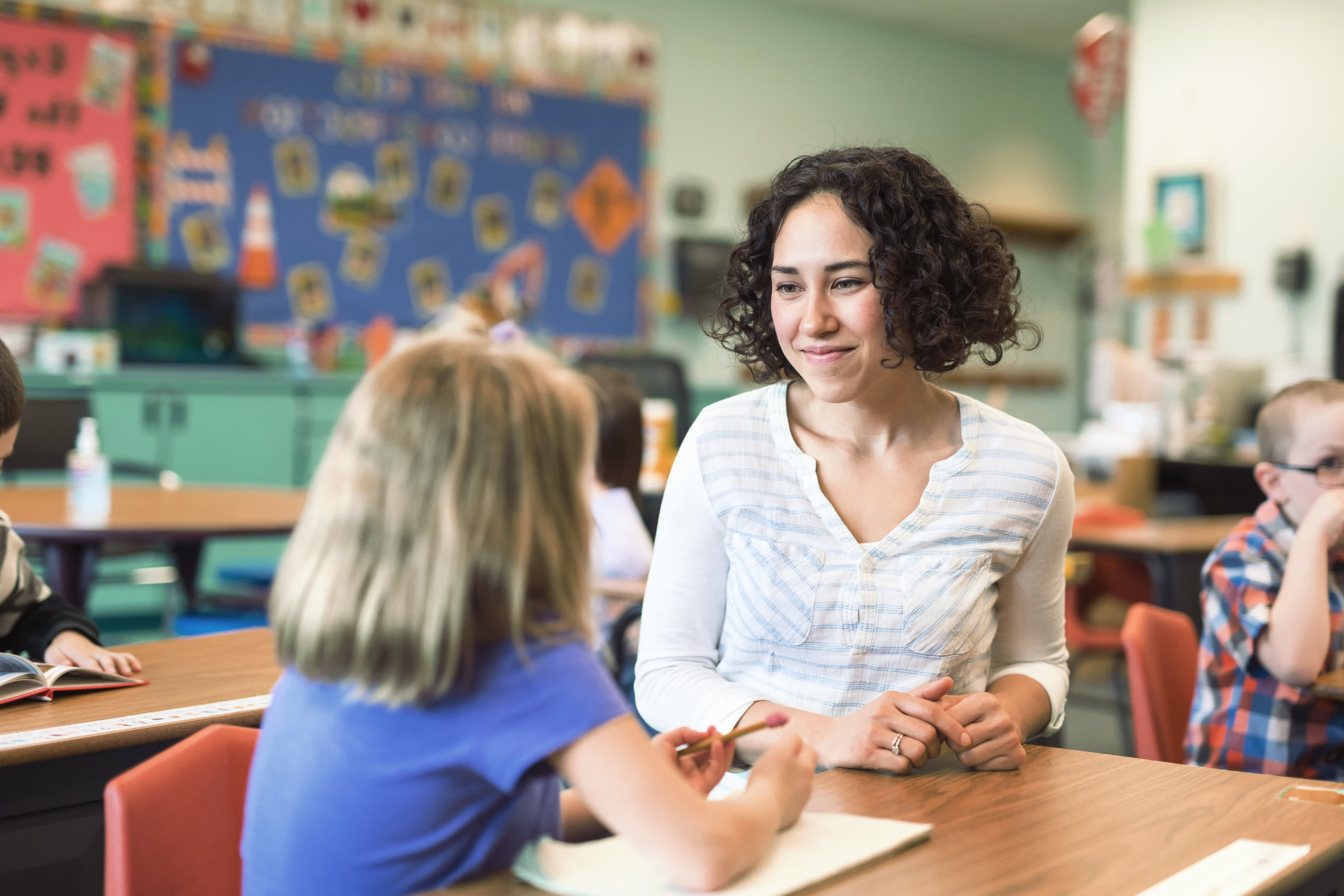 Titelbild für Studiengangseite duales Studium Kindheitspädagogik: Pädagogin mit Kind in Schule