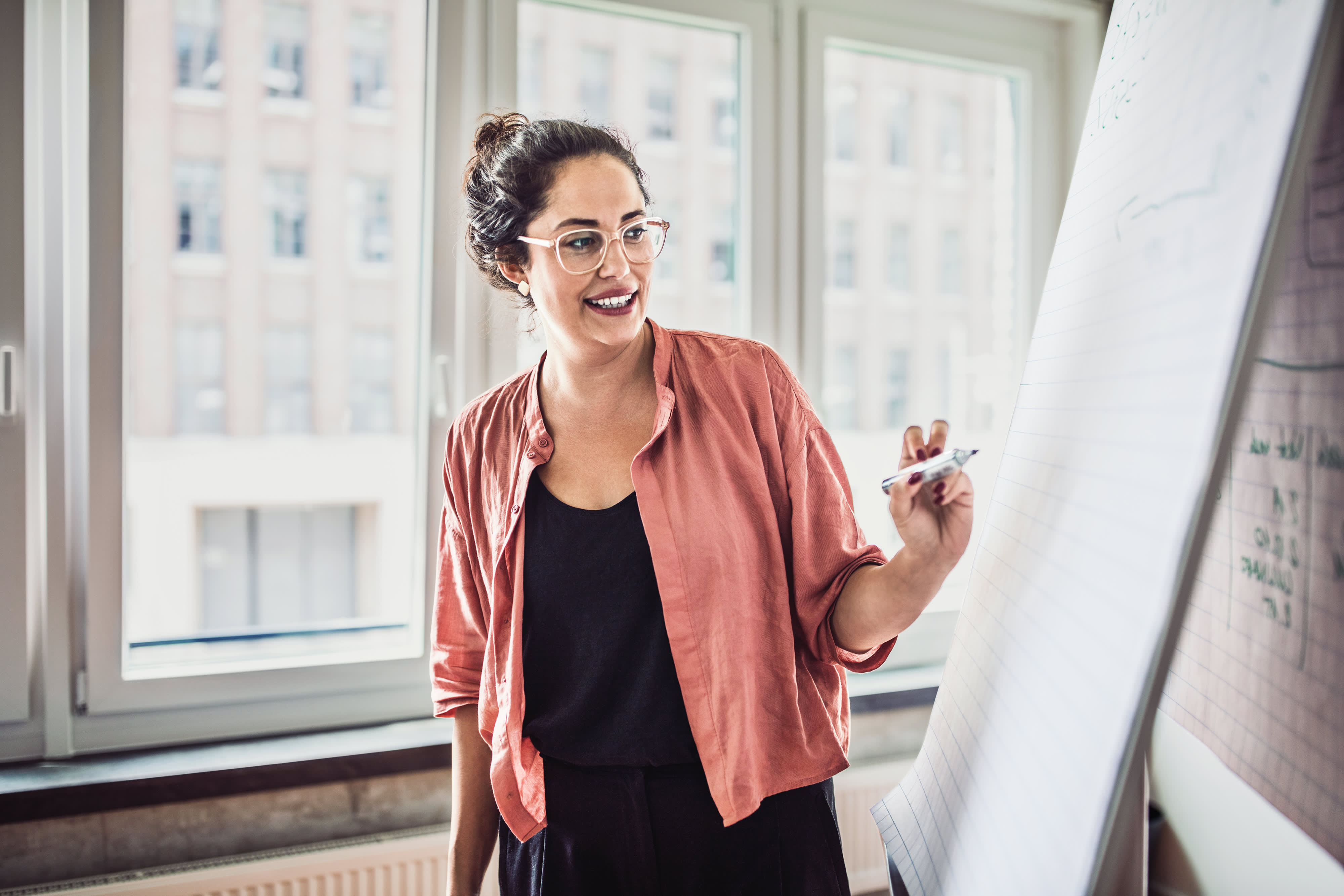 Titelbild für Infoseite “Master Nachhaltiges Management”: Unternehmensberaterin steht vor Whiteboard