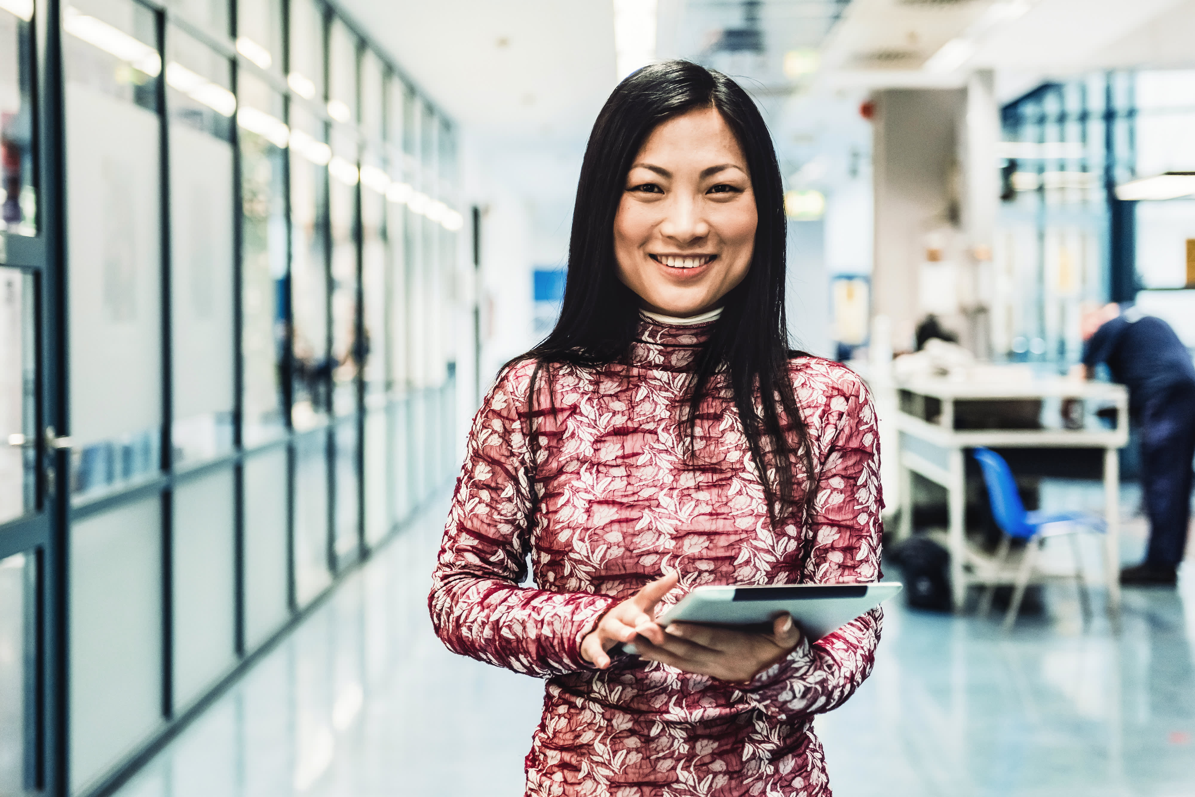 Titelbild für Infoseite “Bachelor Wirtschaftsingenieurwesen Maschinenbau”: Lächelnde Frau mit Tablet im Büro
