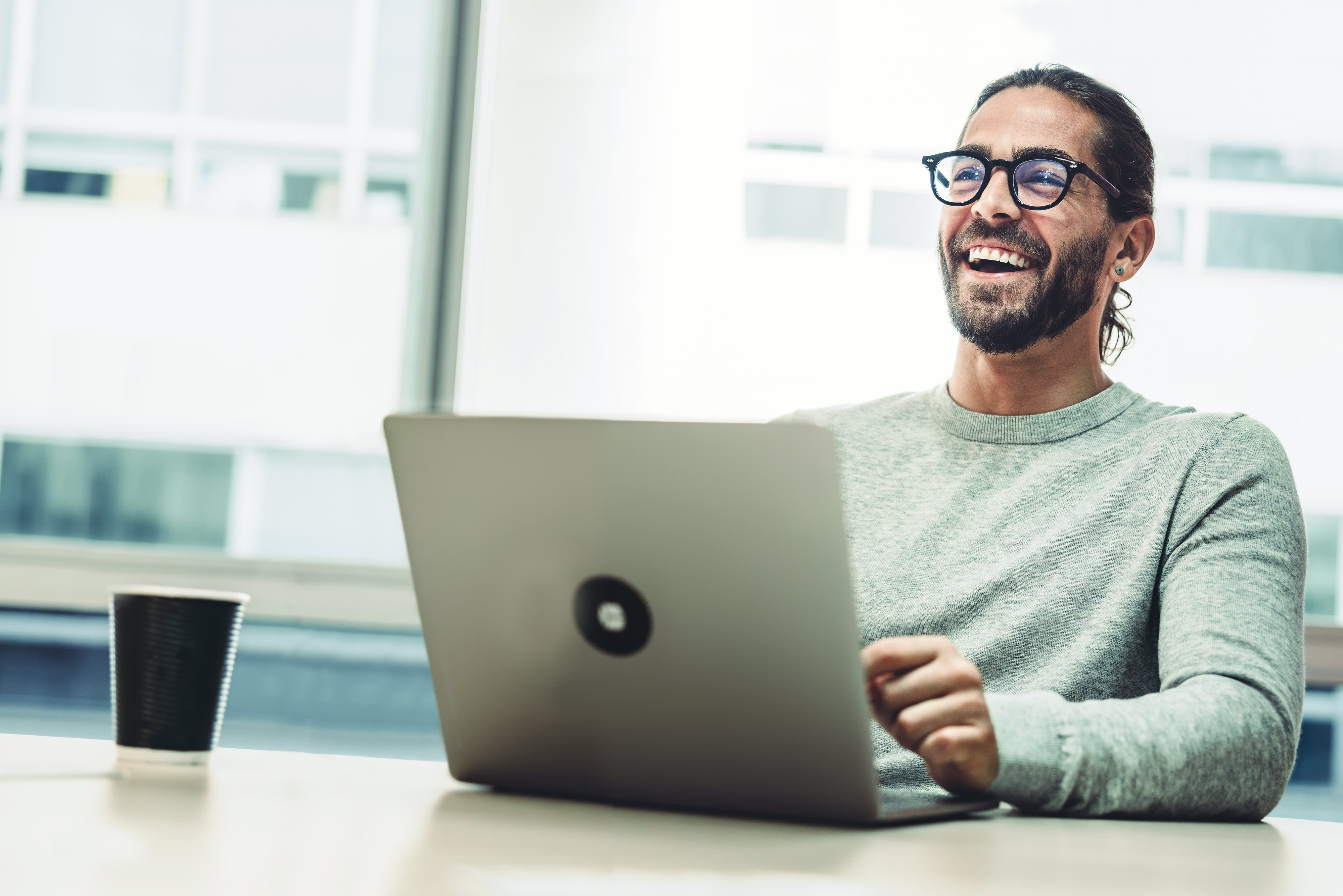 Titelbild für Infoseite “Master Growth Hacking for Entrepreneurs”: Growth Manager arbeitet am Laptop im Büro