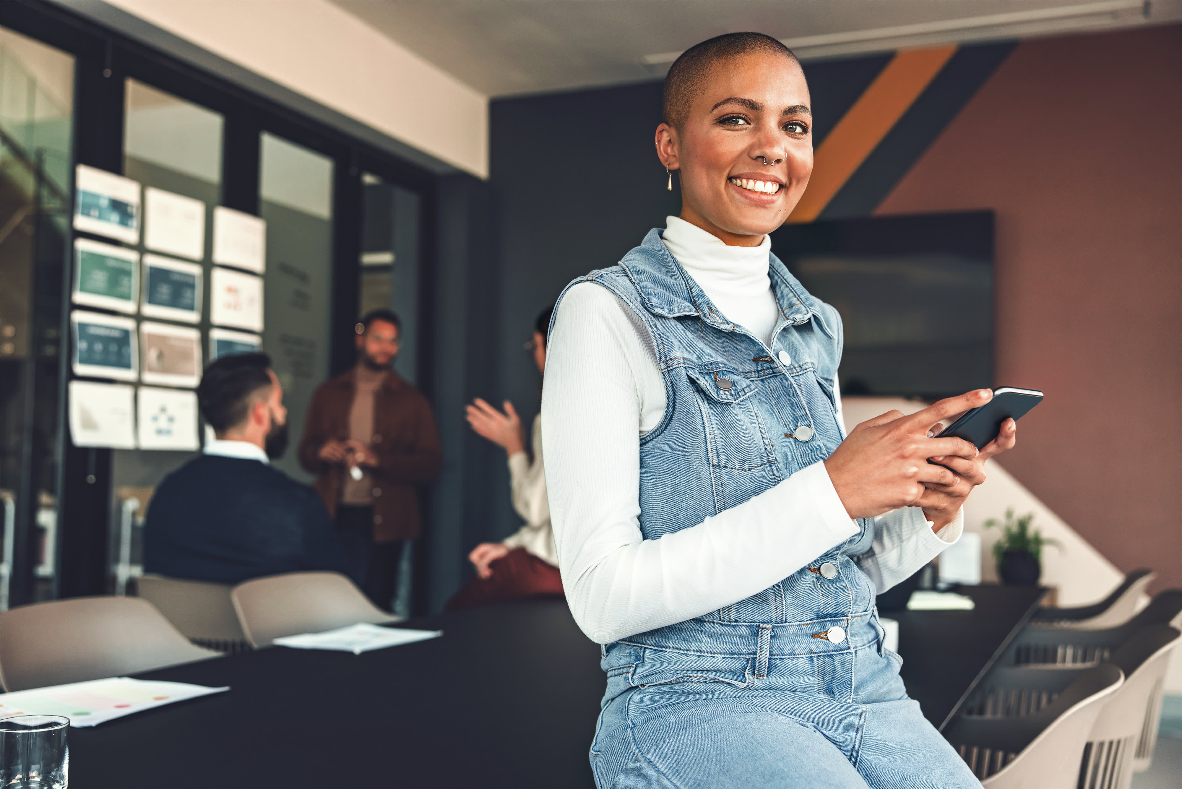 Titelbild für Infoseite “Bachelor BWL und Customer Experience Management”: Frau mit Smartphone im Besprechungsraum