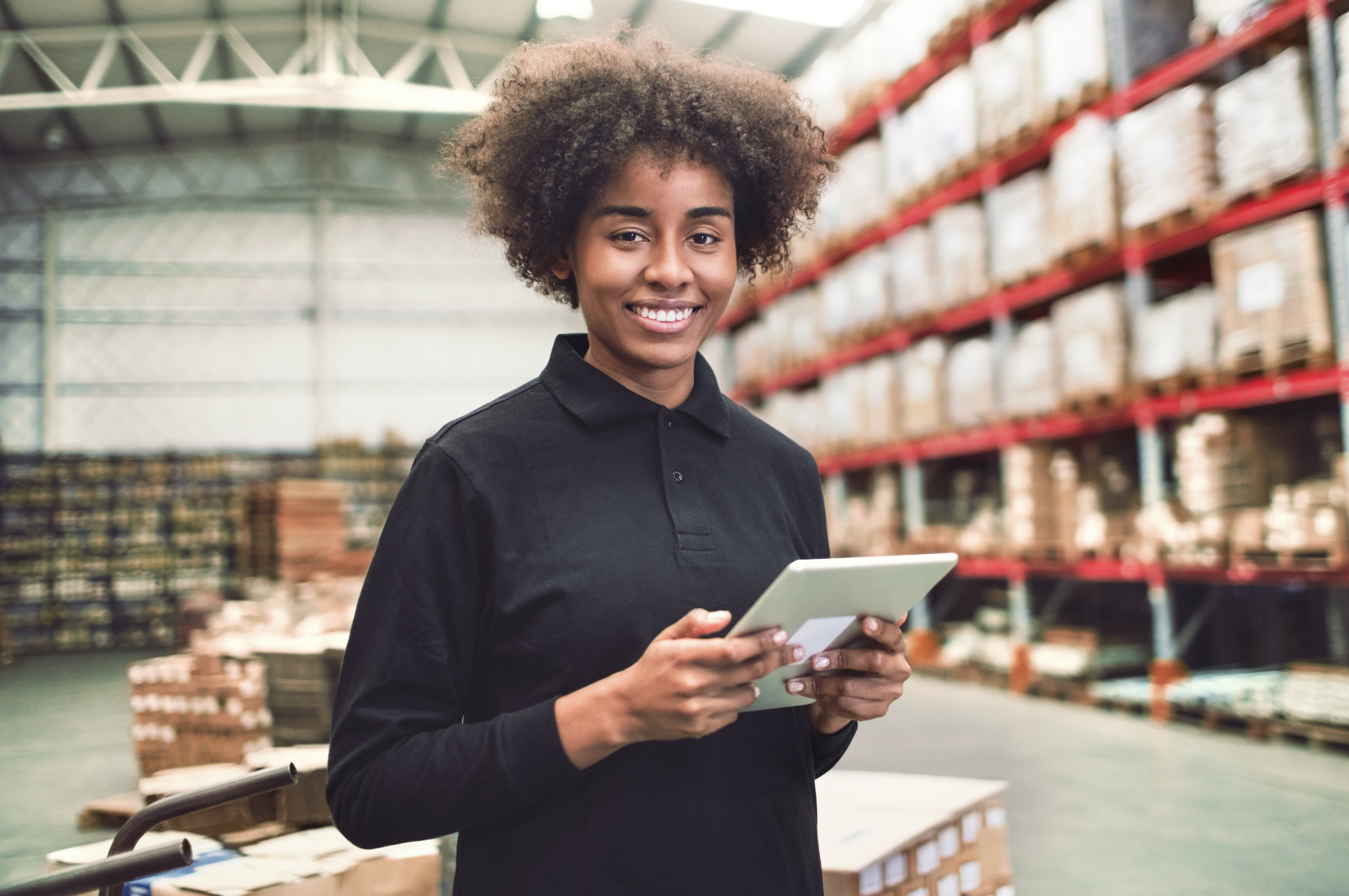 Titelbild für Infoseite “duales Studium BWL Logistikmanagement": Lächelnde Studentin in Lager