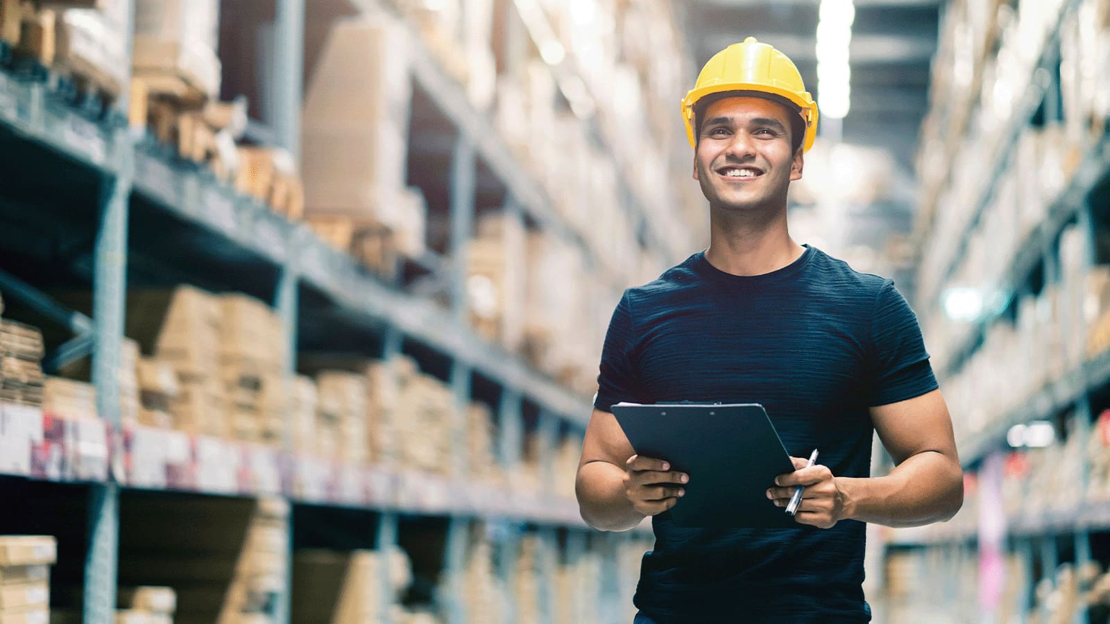 A man wearing a yellow helment in a storage area