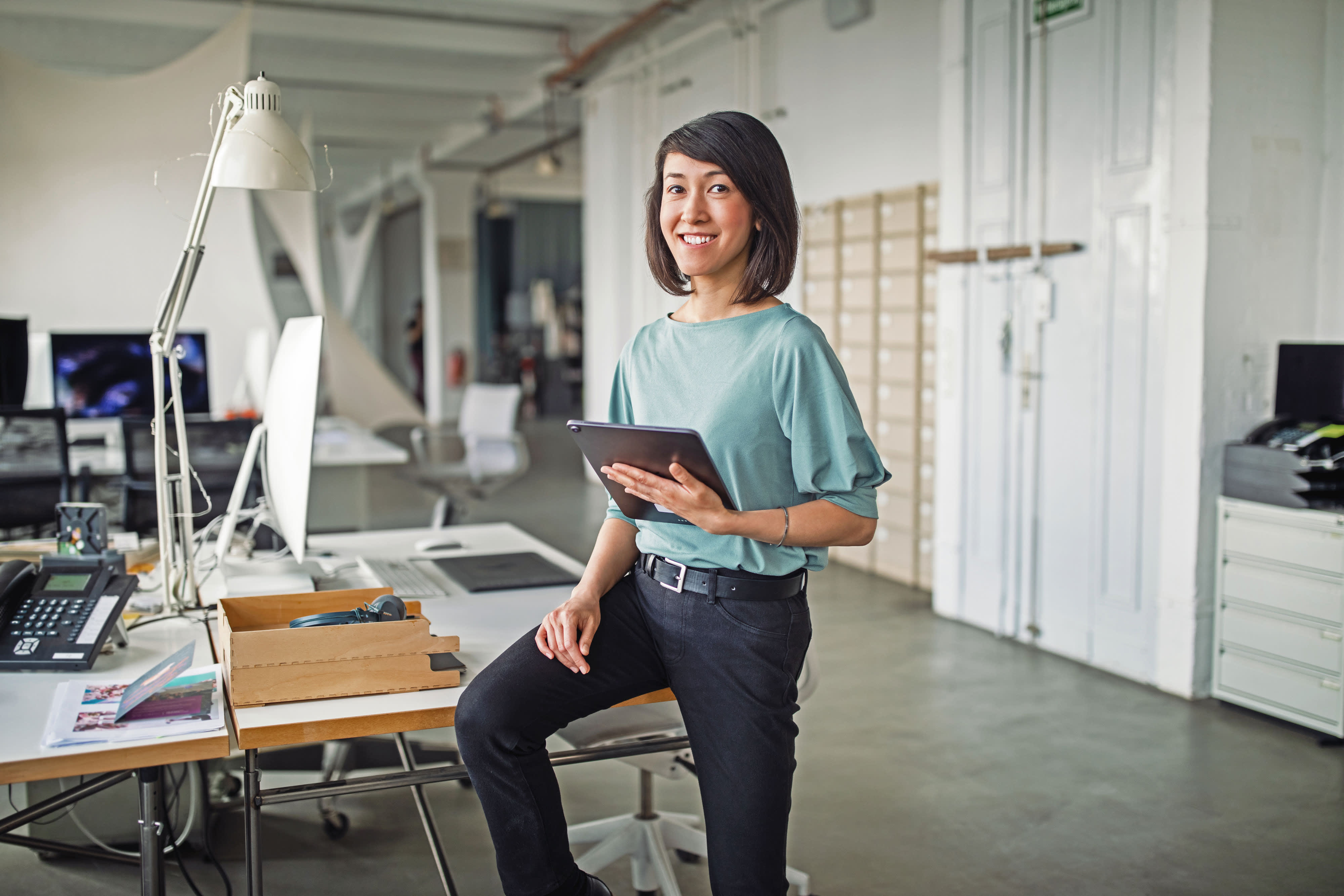 Titelbild für Infoseite “IU Leitbild zum Thema Diversity und Gleichstellung”: Frau mit Tablet im Büro