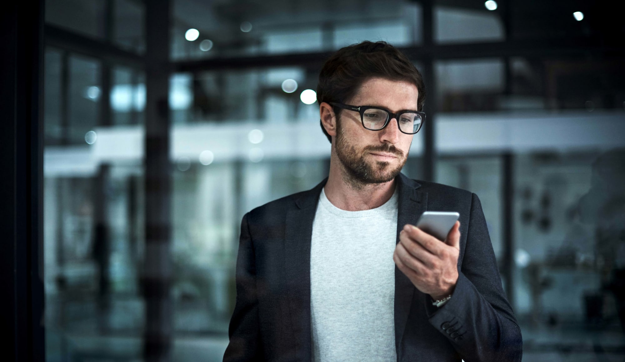 Unternehmer hält sein Telefon in der Hand und schaut darauf
