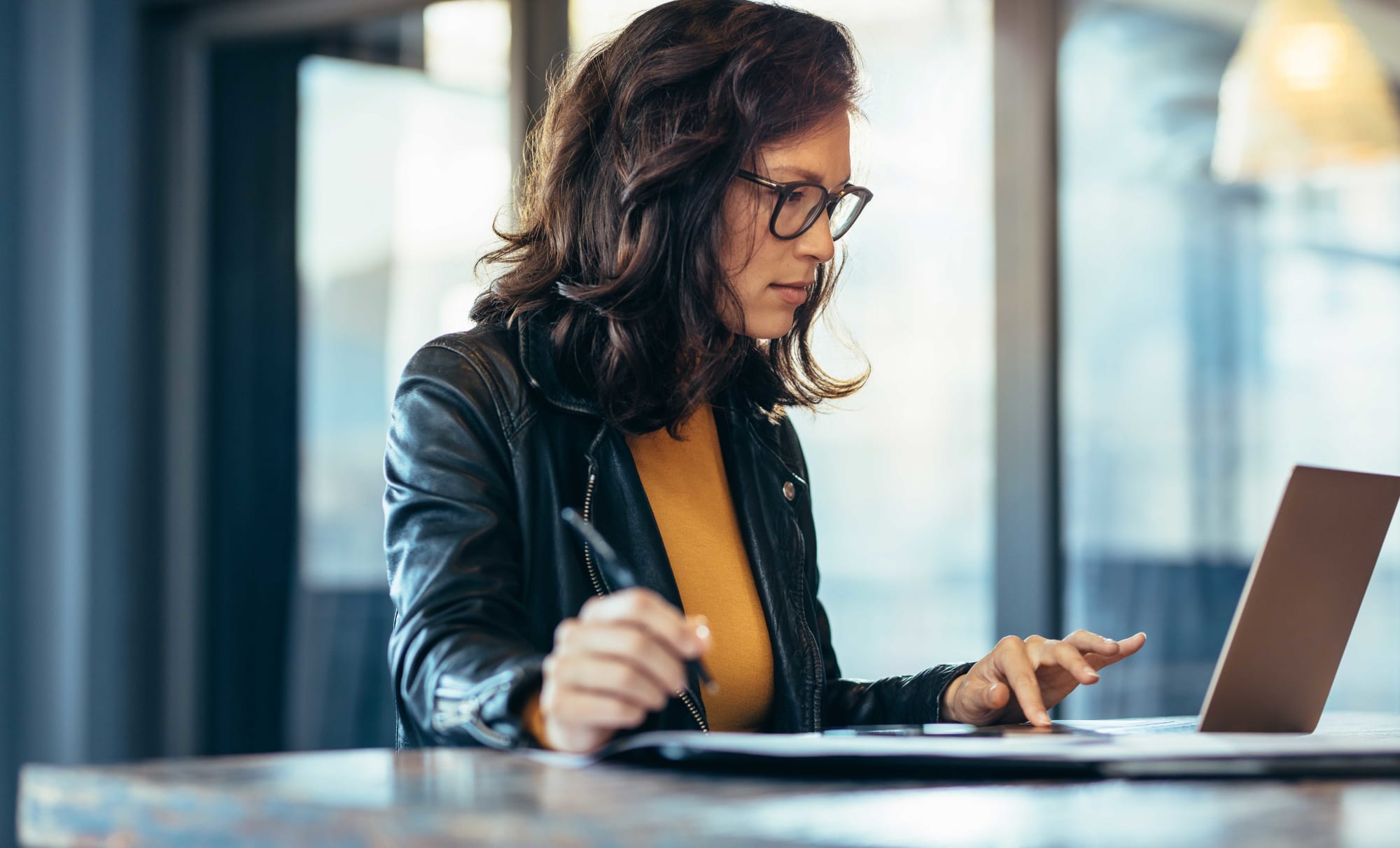 Frau mit Brille arbeitet konzentriert am Laptop