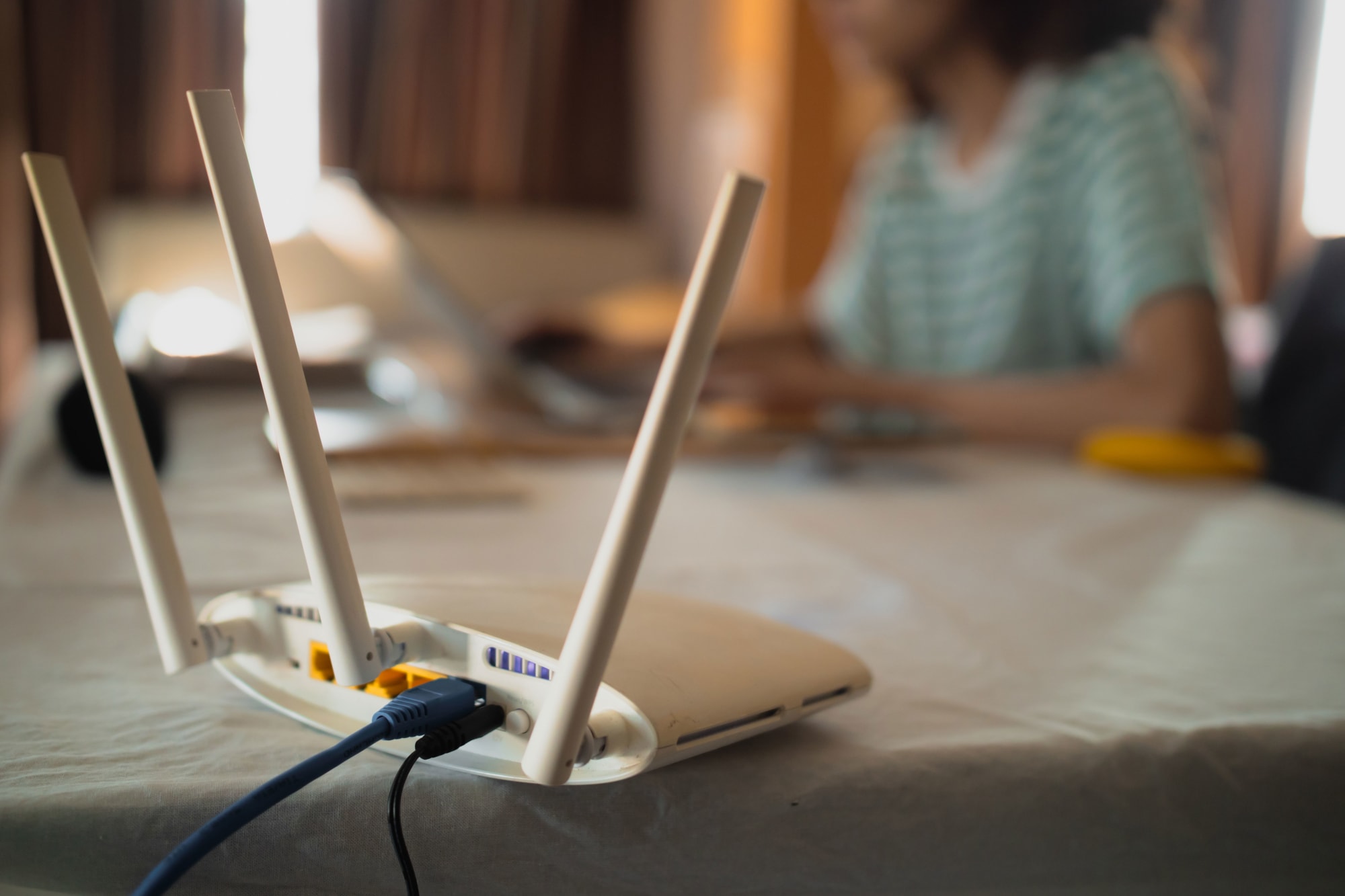 Router Platzierung auf Tisch für gutes WLAN Signal mit Frau im Hintergrund