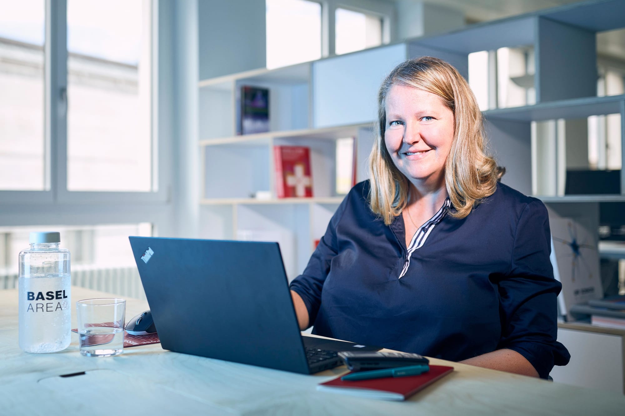 Frau mit Laptop am Schreibtisch im Unternehmen