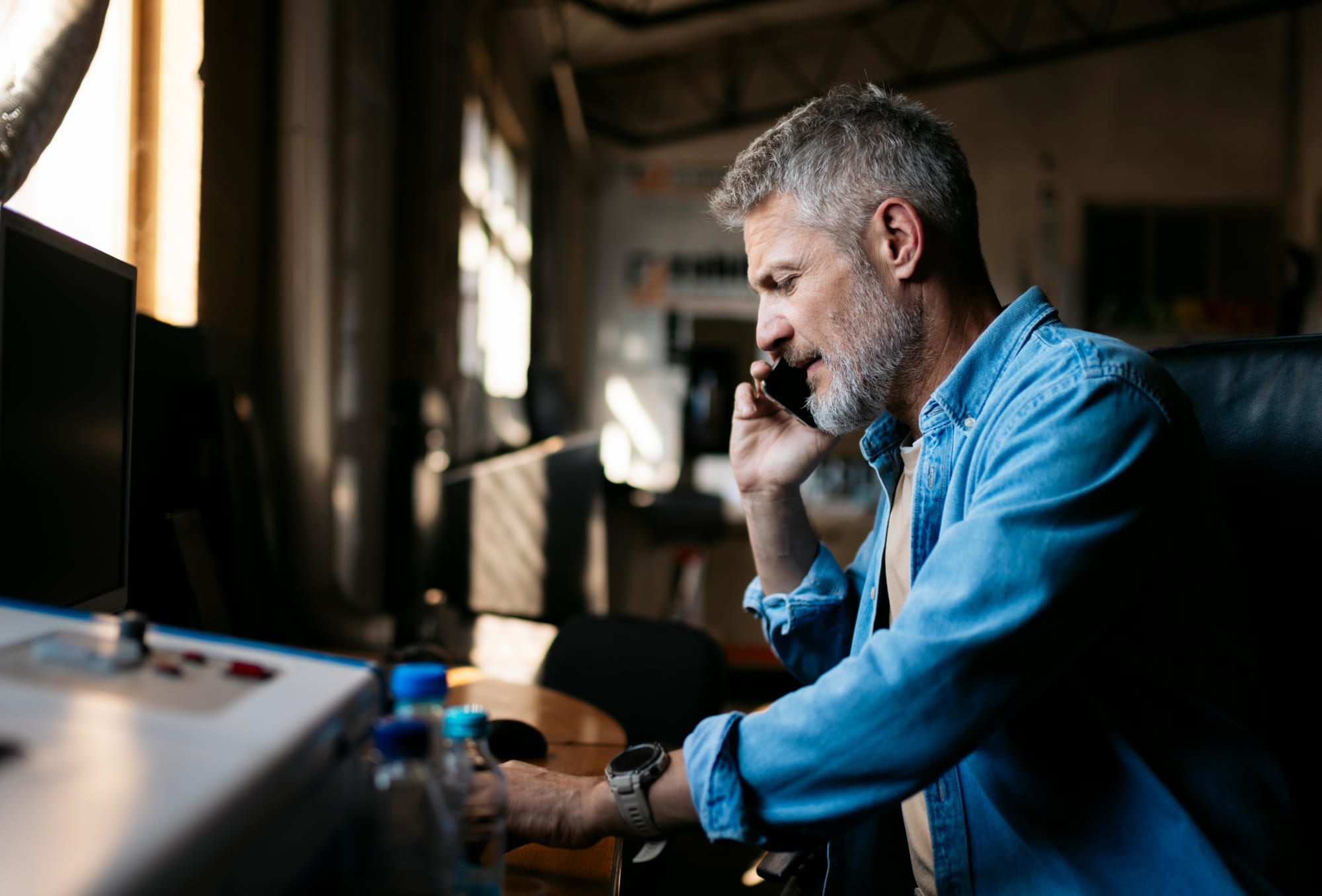 Handwerker im Büro telefoniert und arbeitet