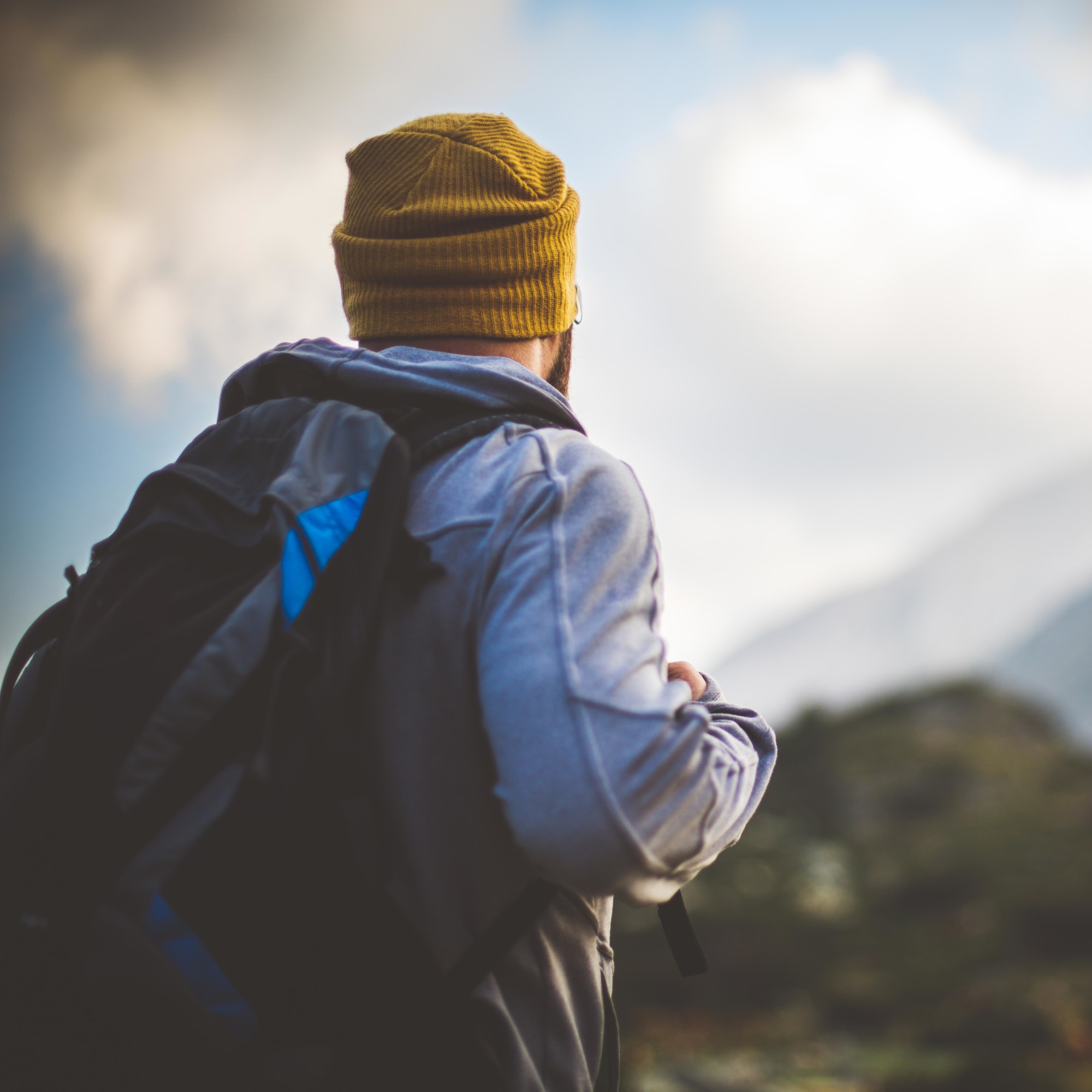 Mann in den Bergen mit bewölktem Himmel
