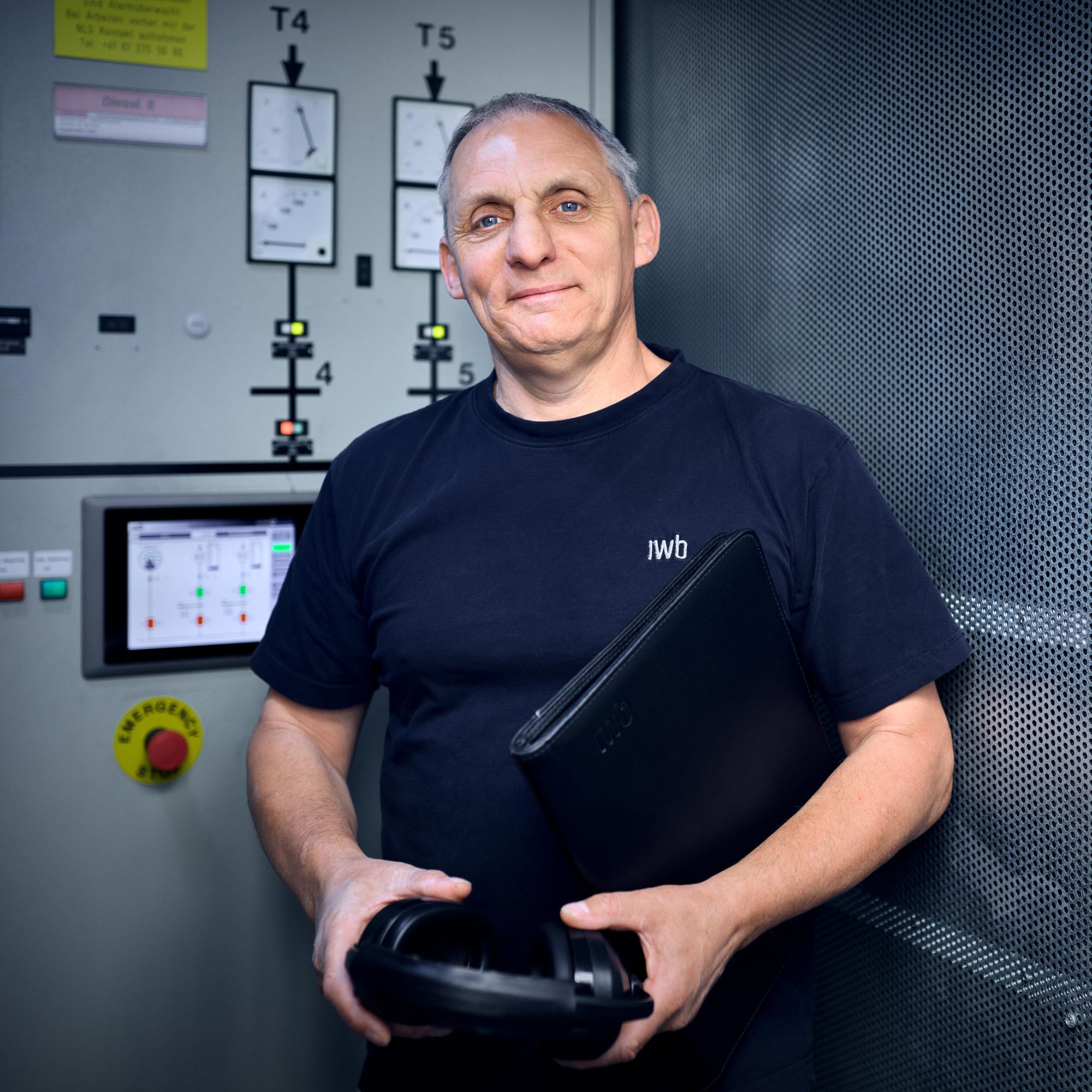 Mann mit Kopfhoehrern in der Hand an Notgenerator im IWB Datacenter