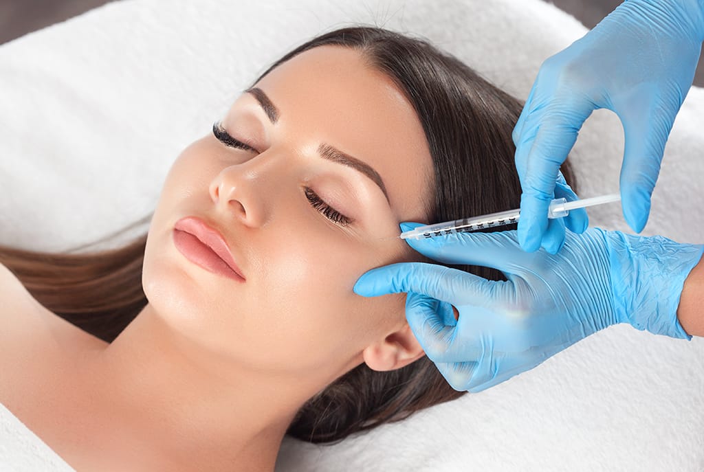 Doctor administering a Botox injection to soften forehead lines