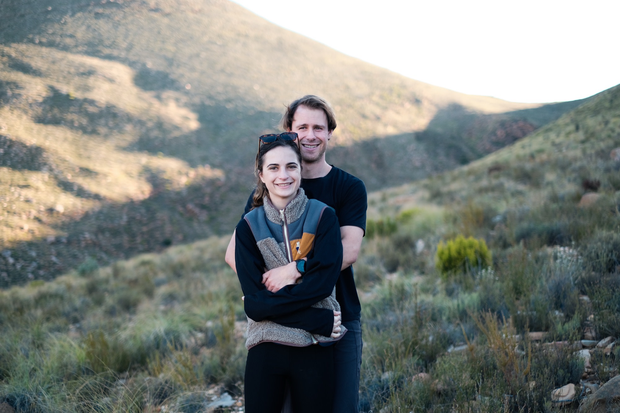 Tristan and Erin embracing on a mountain trail