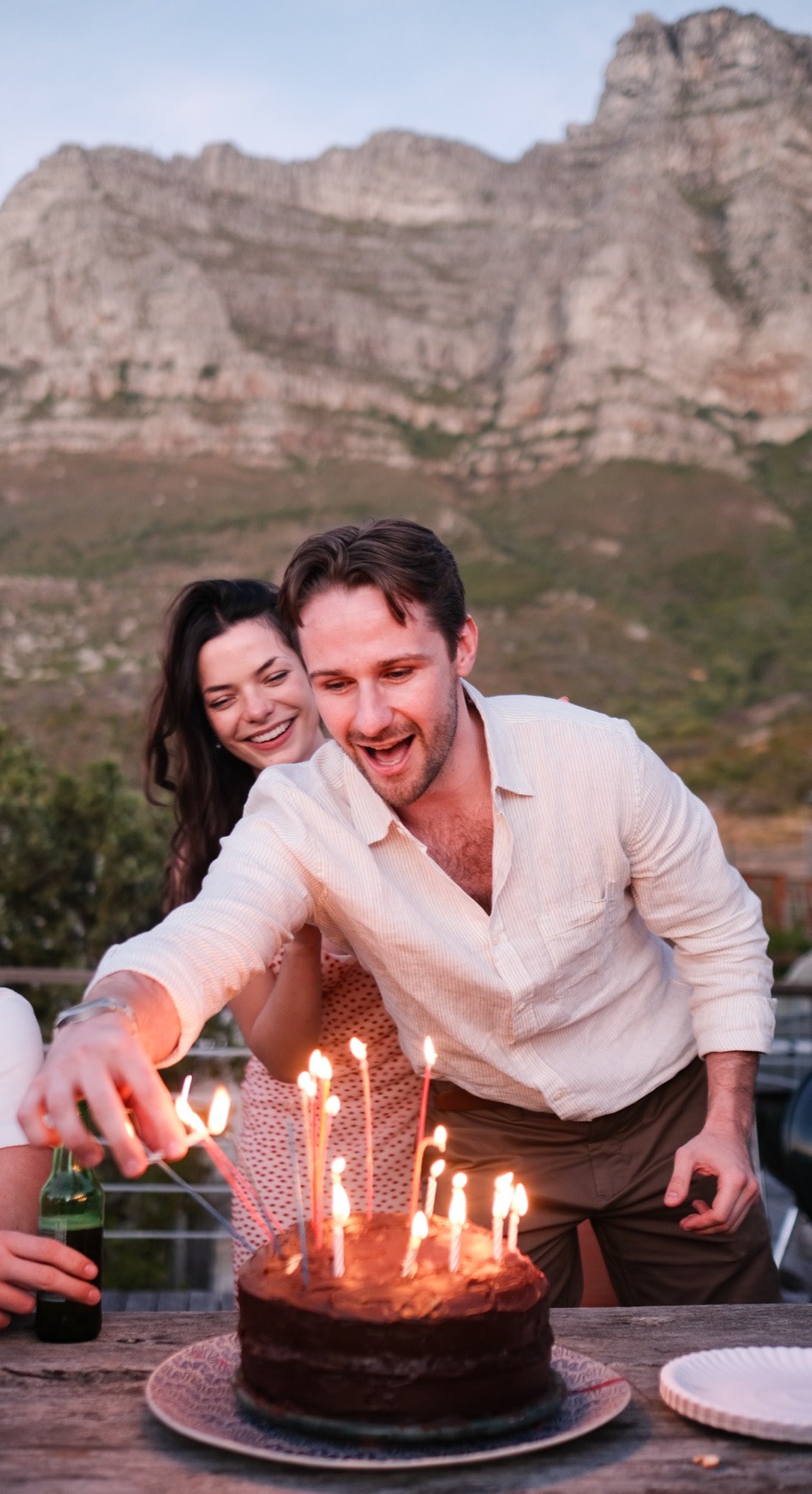 The couple light the cake candles together