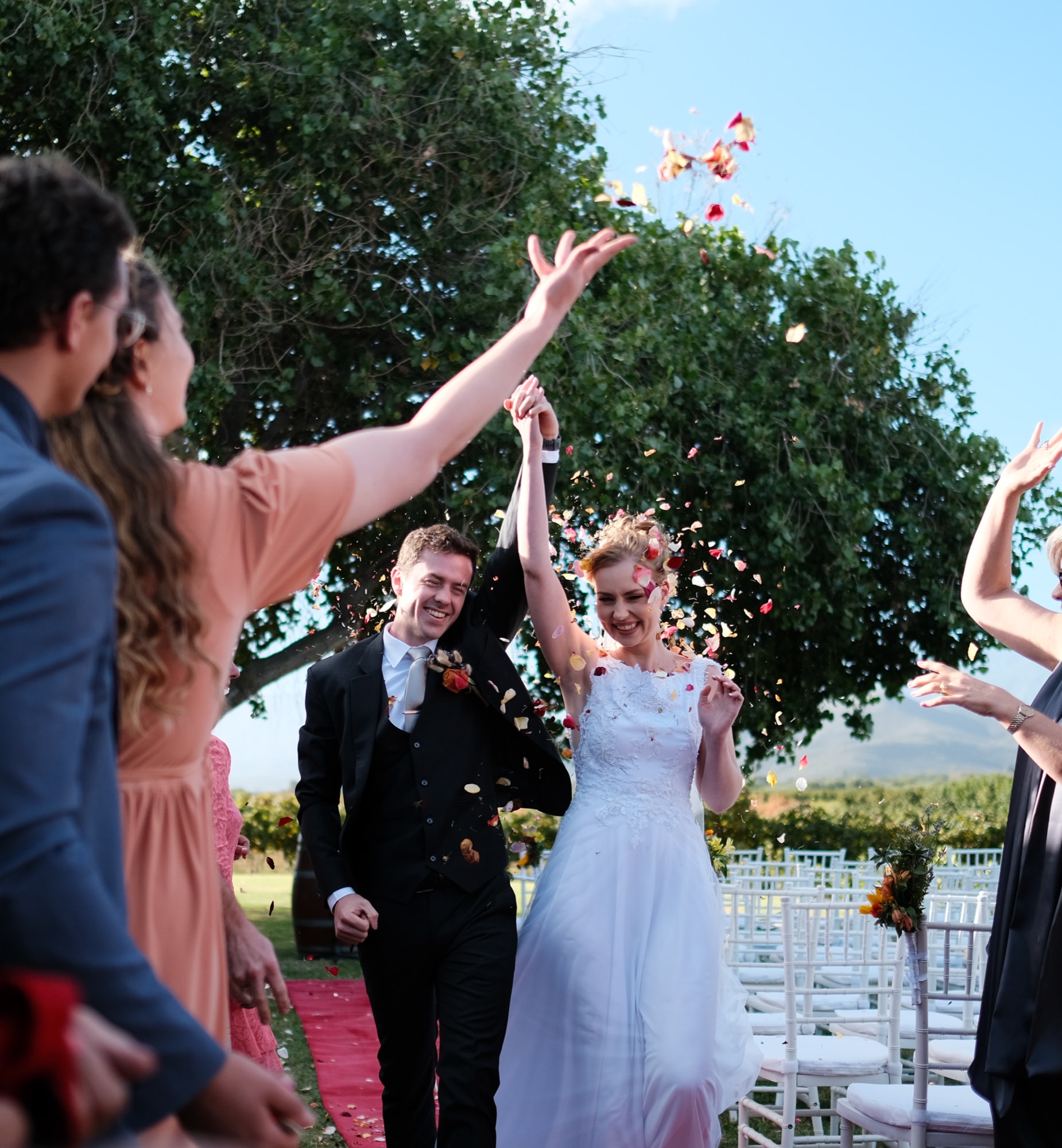The couple walk back down the aisle through a shower of petals