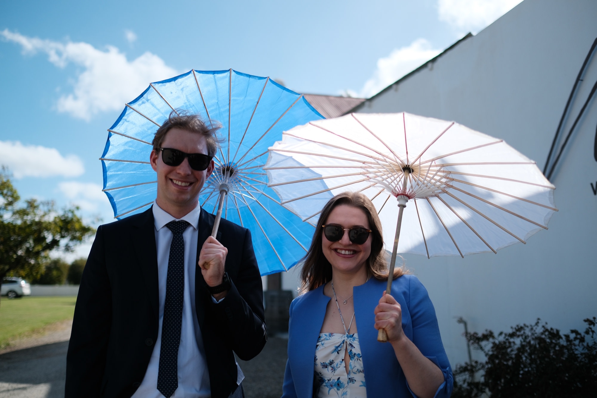 Two guests posing with parasols in the afternoon sun