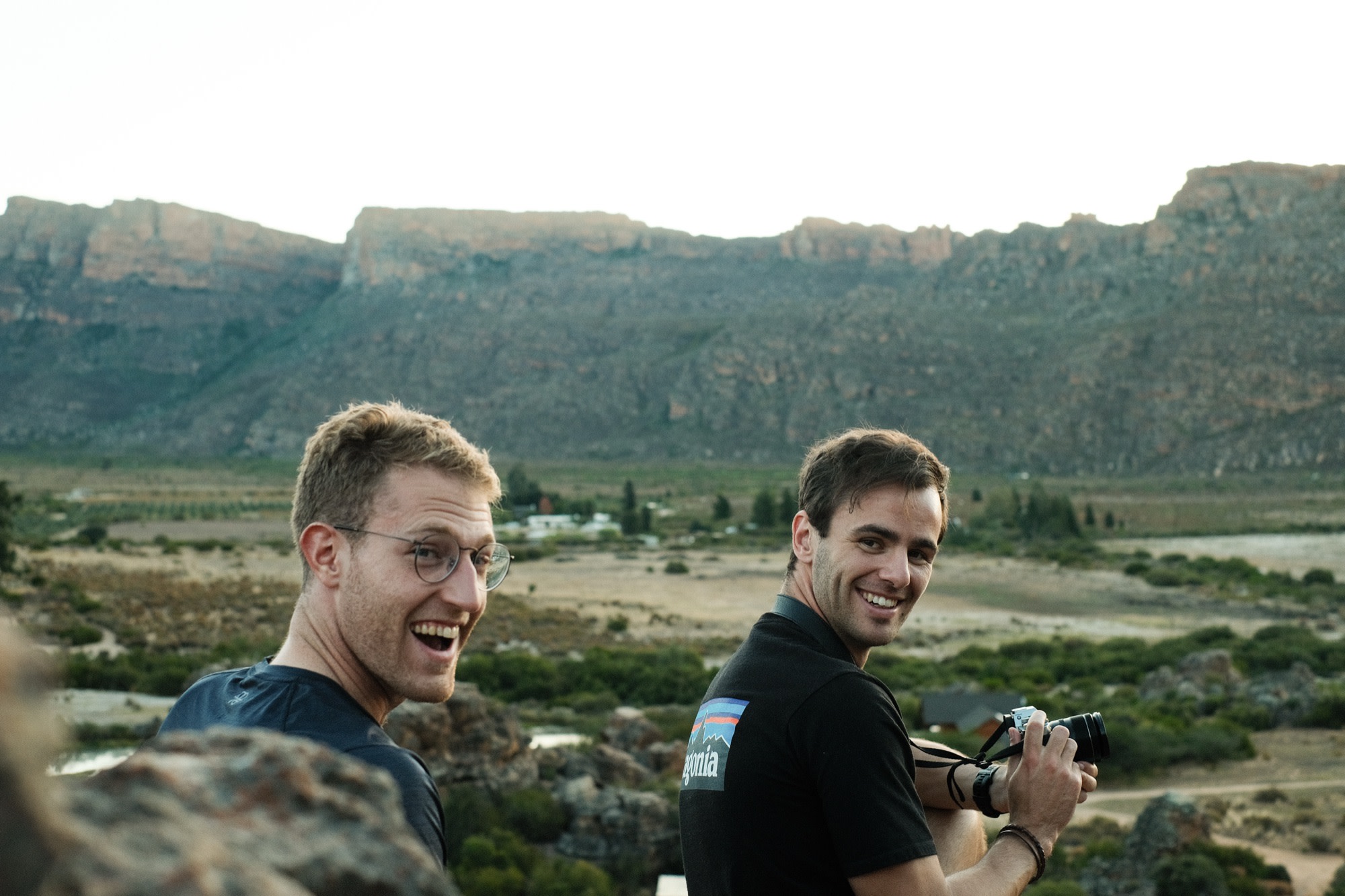Two friends laughing on a mountain lookout